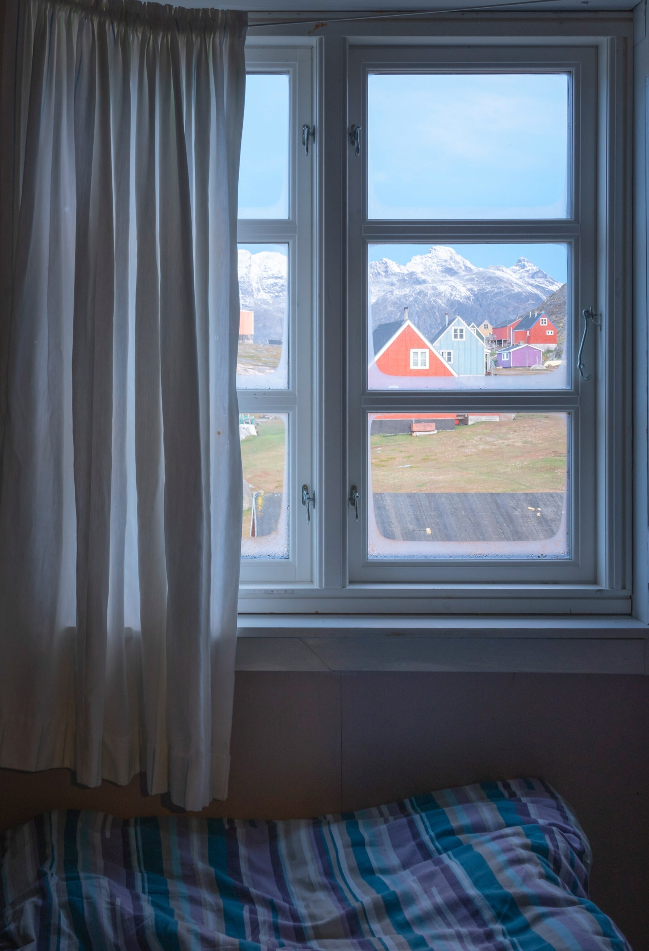 a window view of the village of Tasiusaq in Greenland