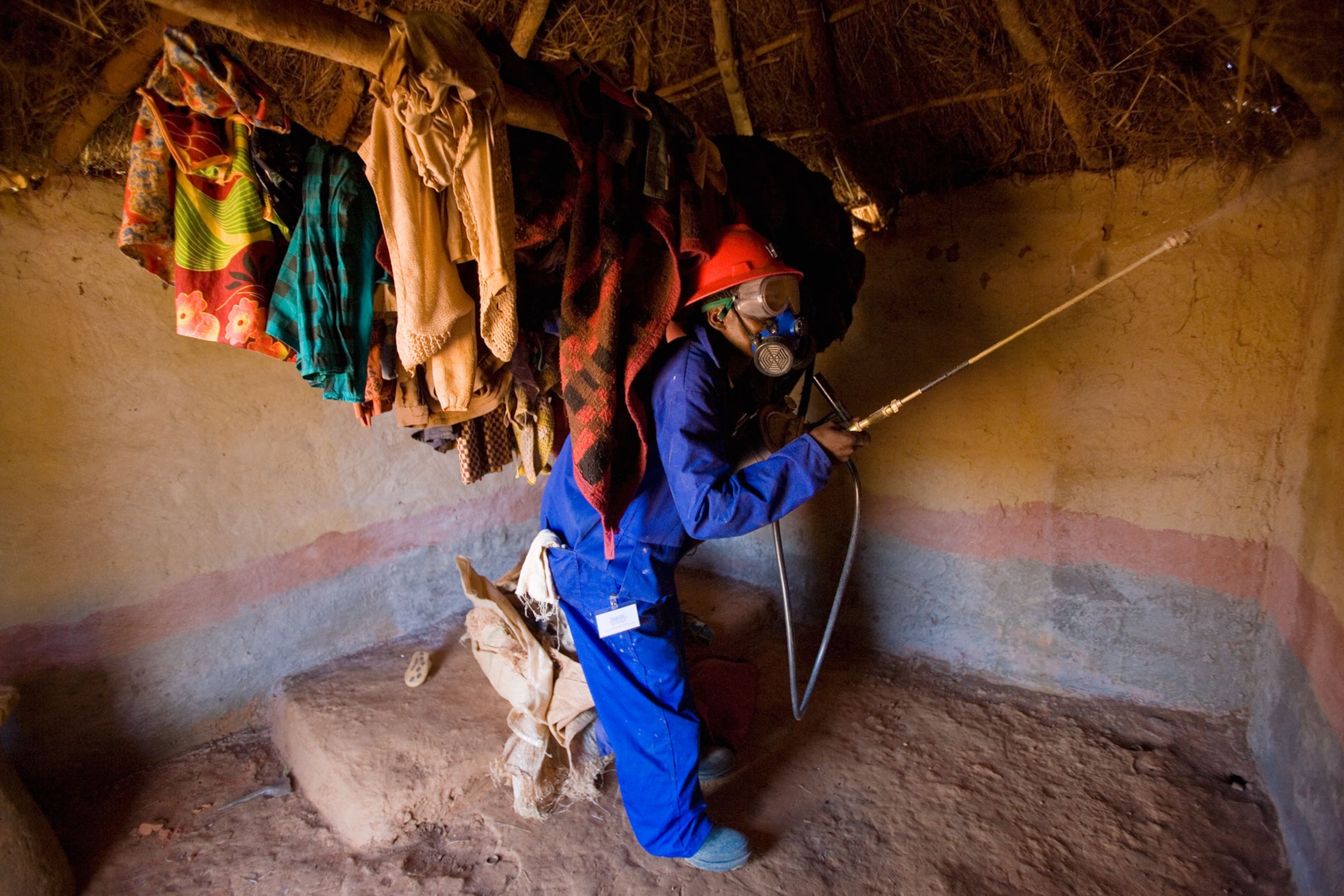 a man spraying DDT in a home in Zambia