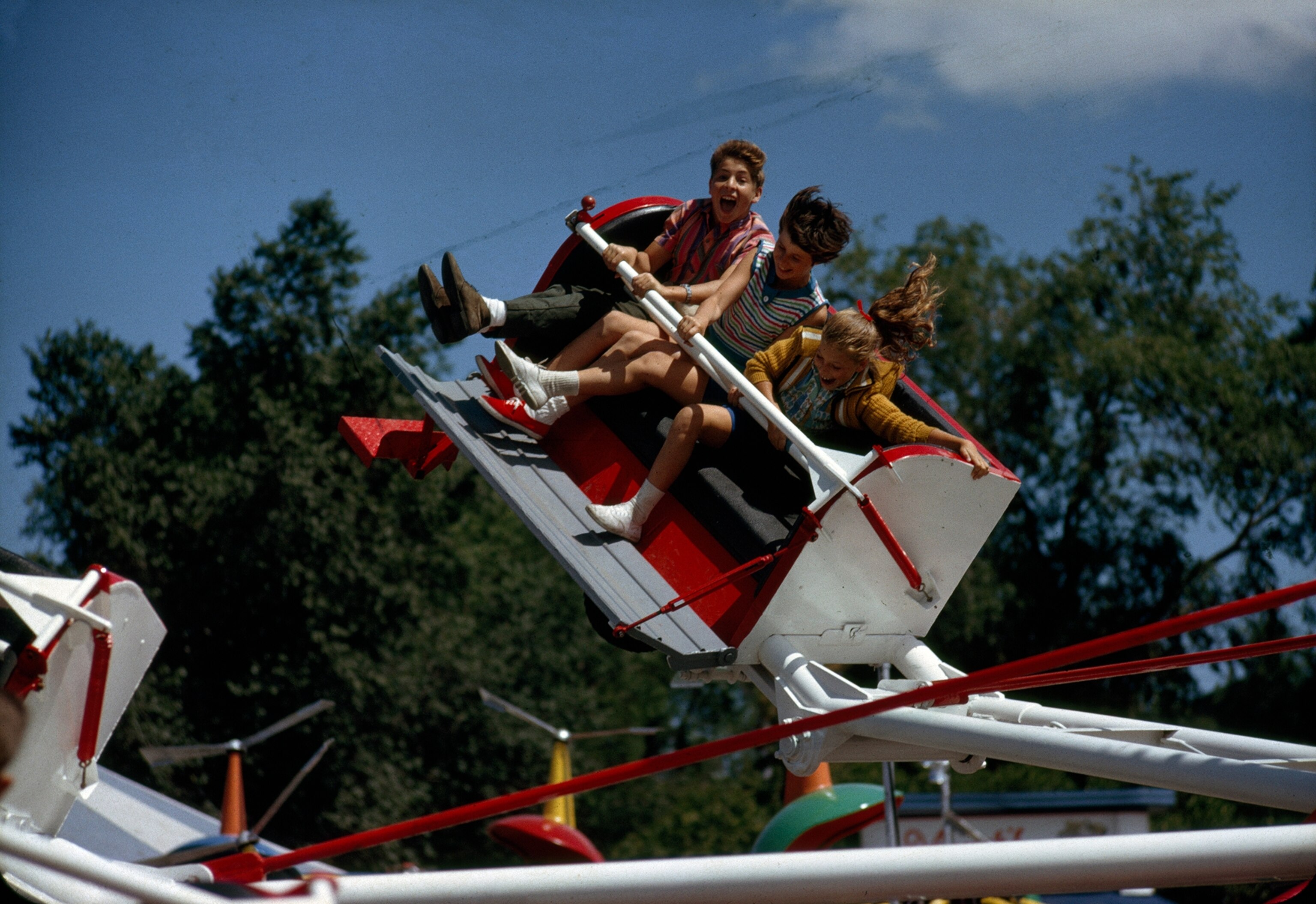 children enjoy an amusement park ride at a summertime exhibition