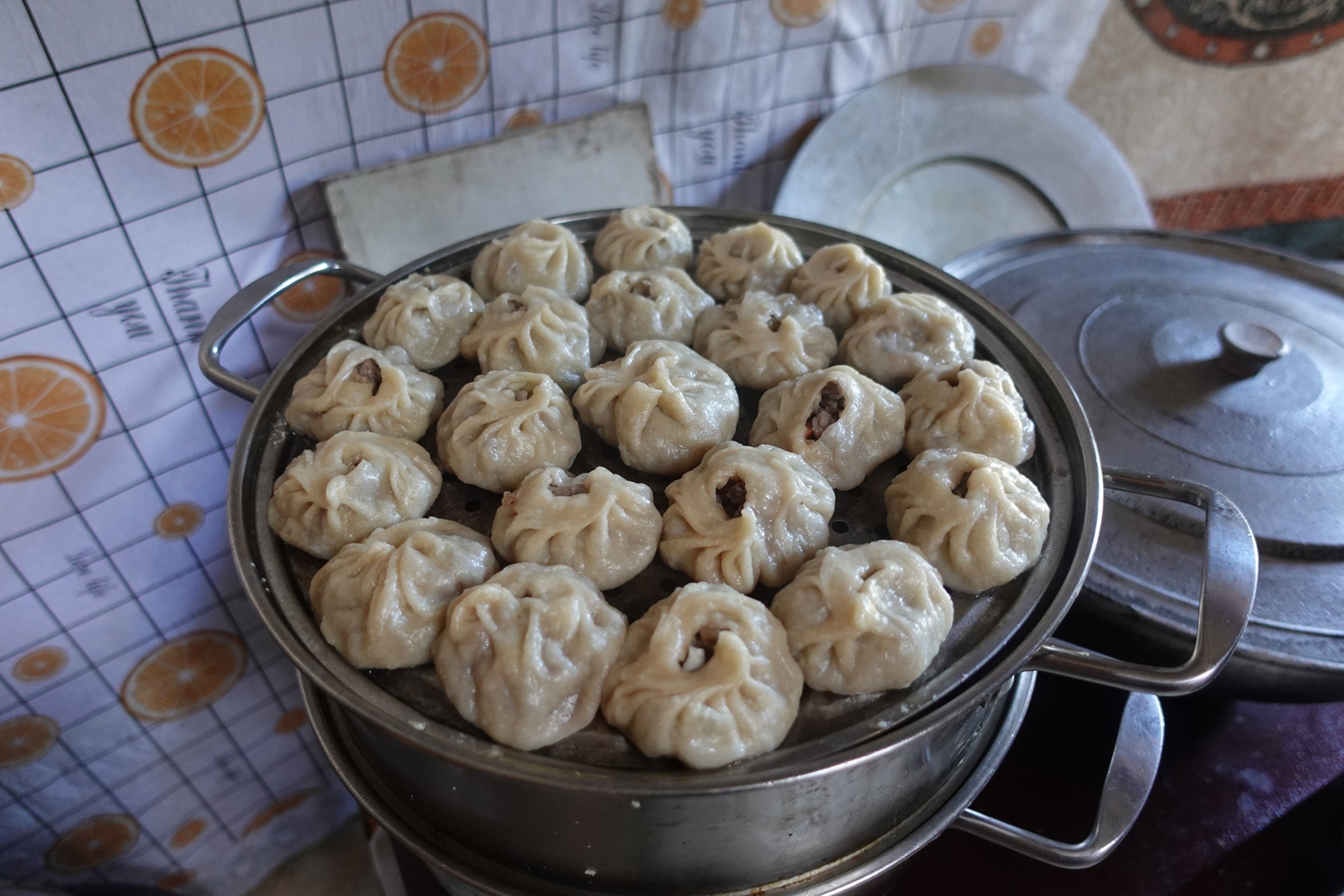 Handmade dumplings in a pot with steam rising out of it.