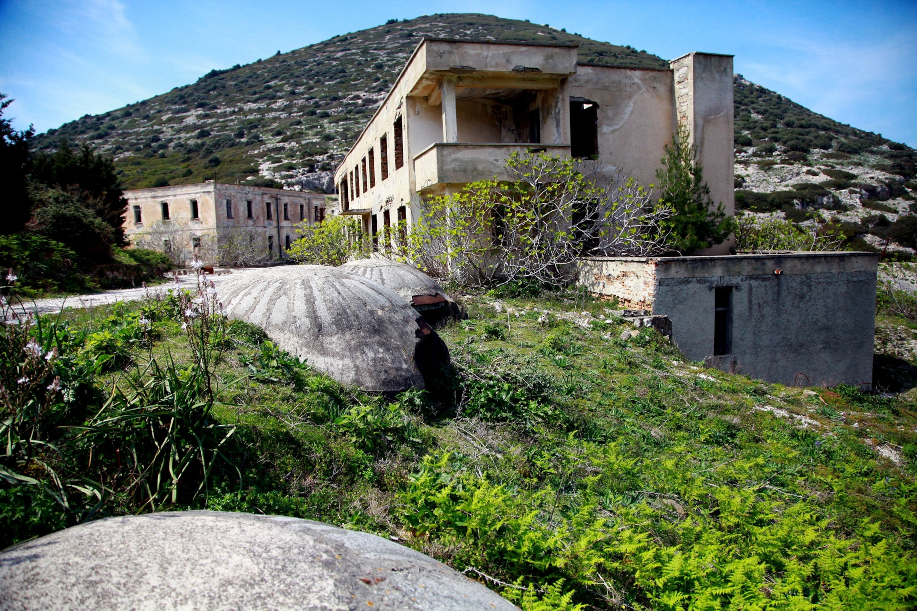Army command buildings sit abandoned on Albania's Sazar Island, as the walls decay and the glass from the windows is missing