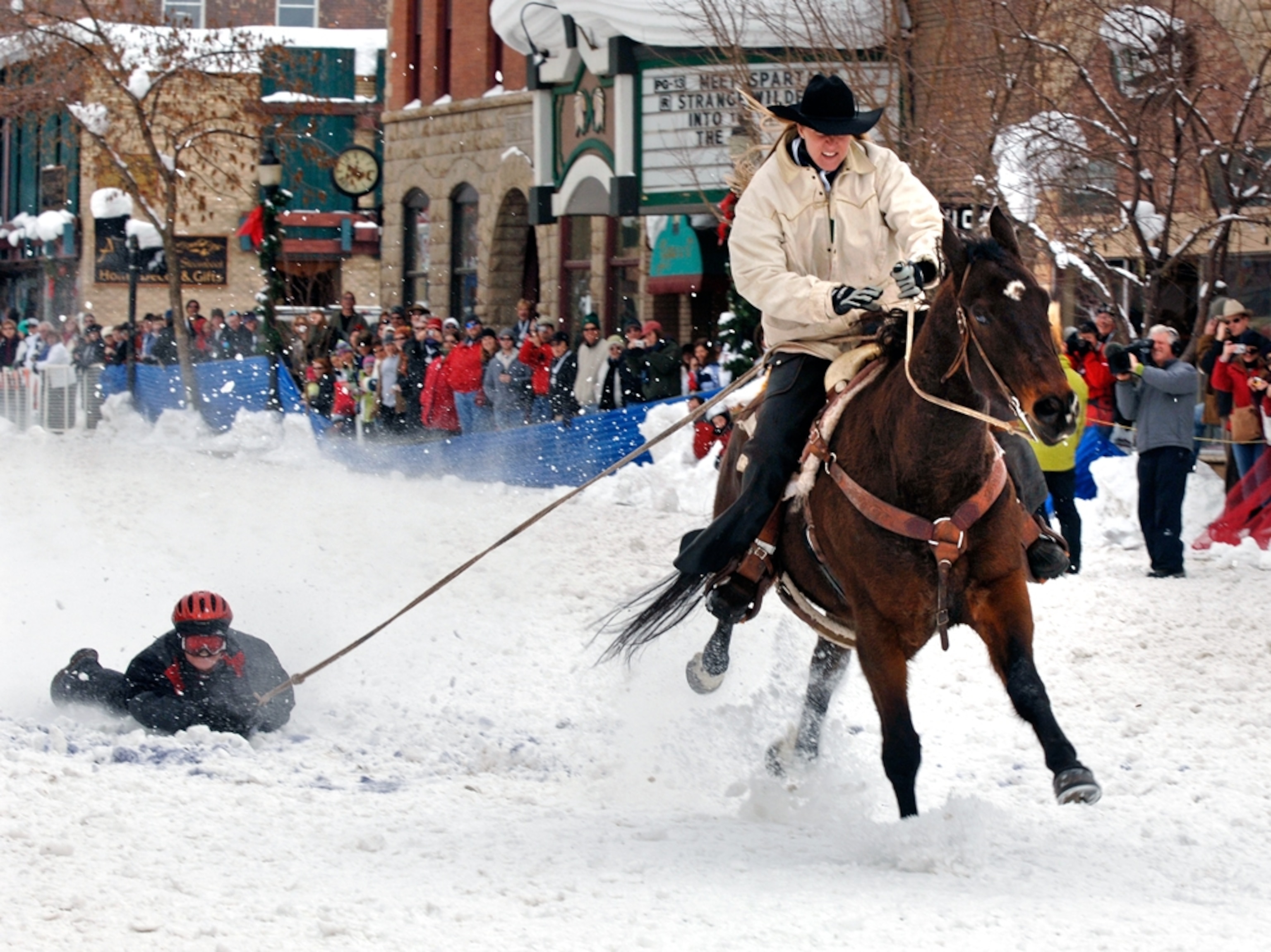 man on shovel being pulled by horse in snow