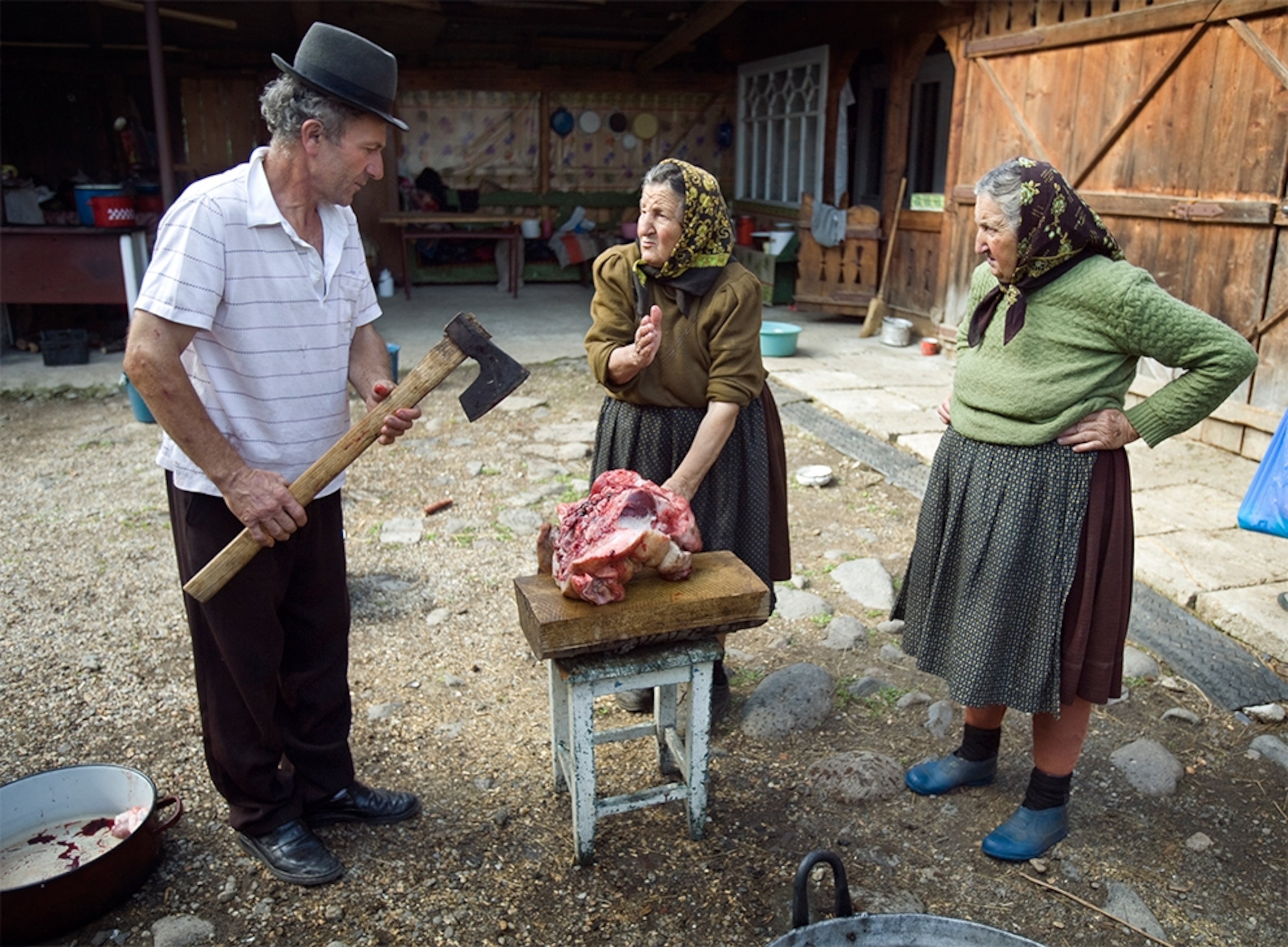 women and man preparing meat, Sarbi, Maramures, Romania
