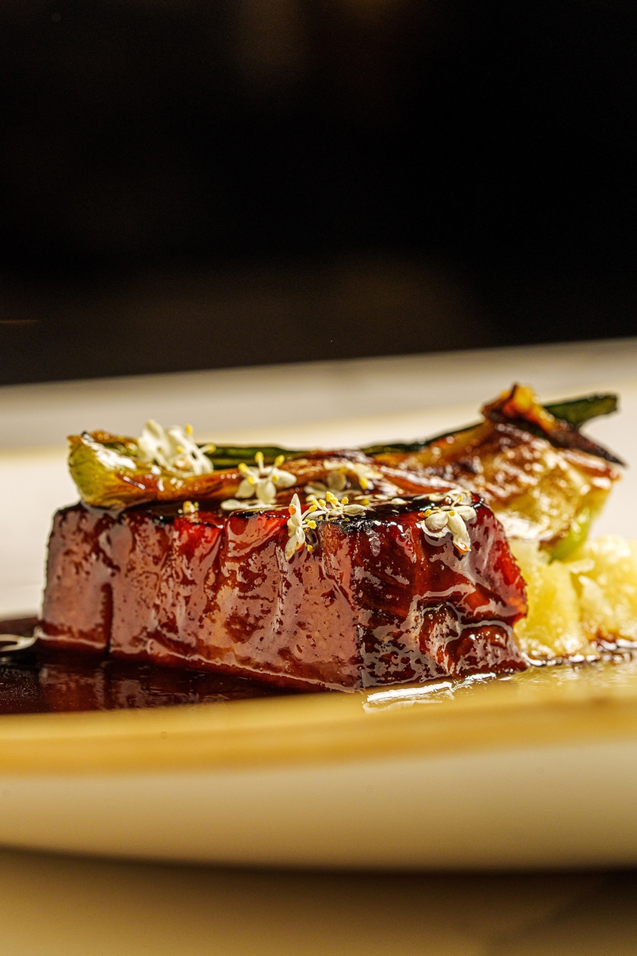 A plate of pork loin artfully presented in a fine dining setting.