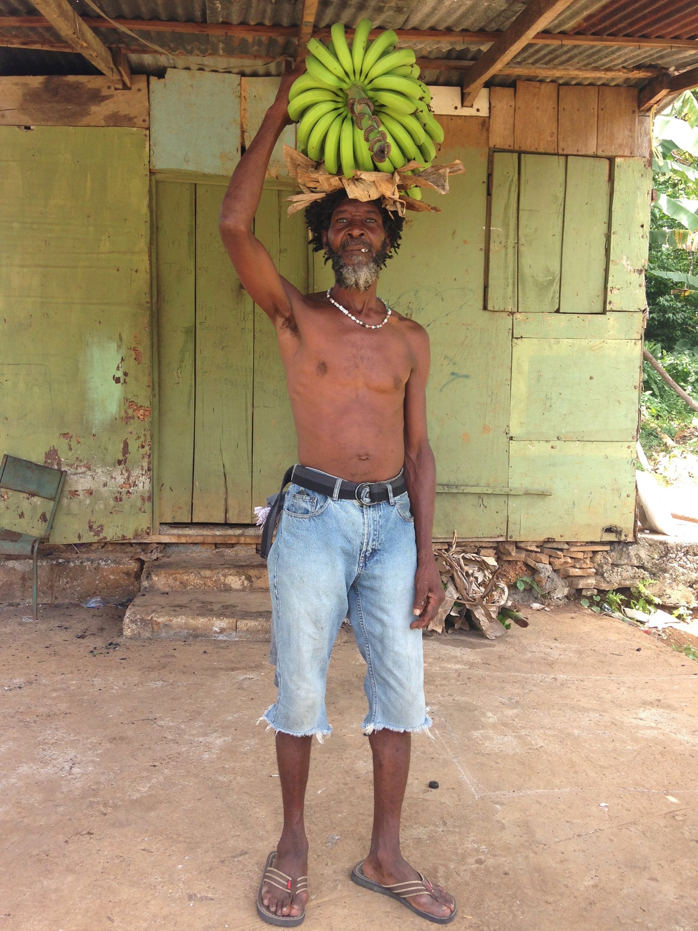 a man carrying bananas on his head