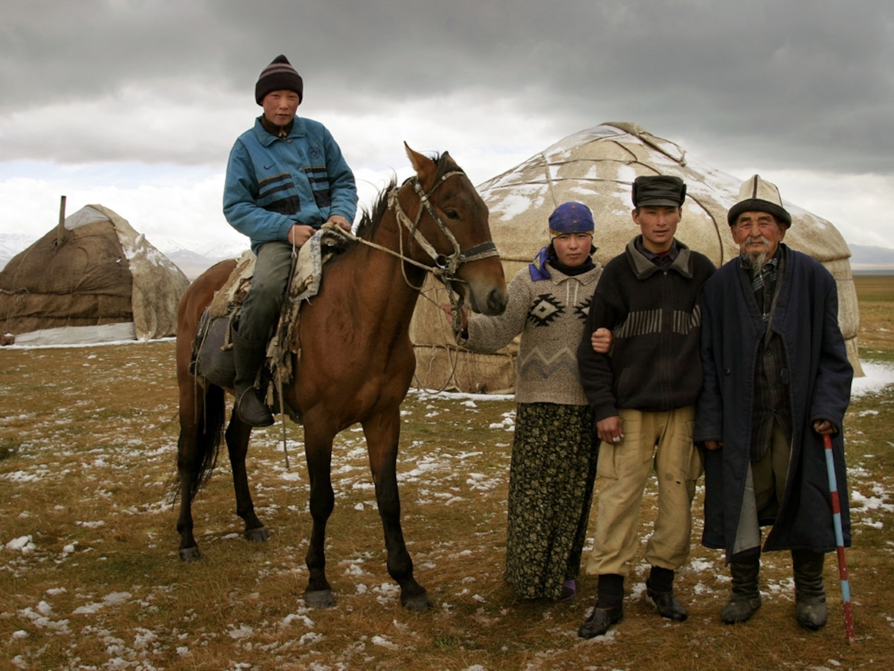 People and a horse in front of round tents
