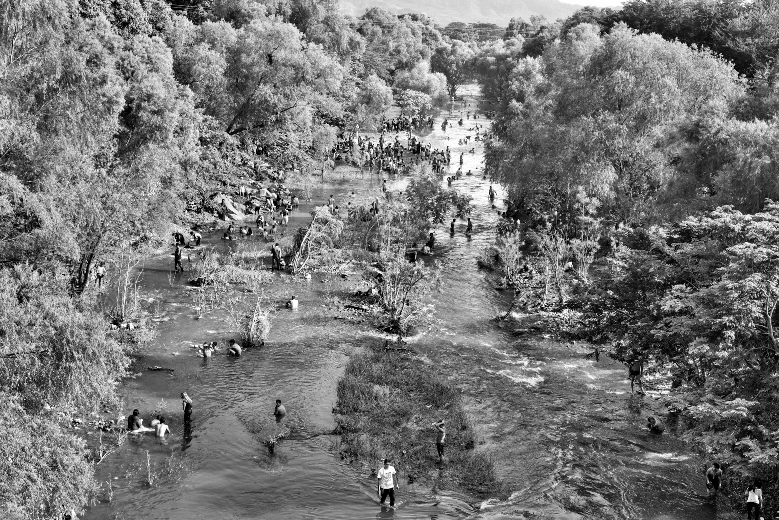an aerial view of a riverbed with many people bathing