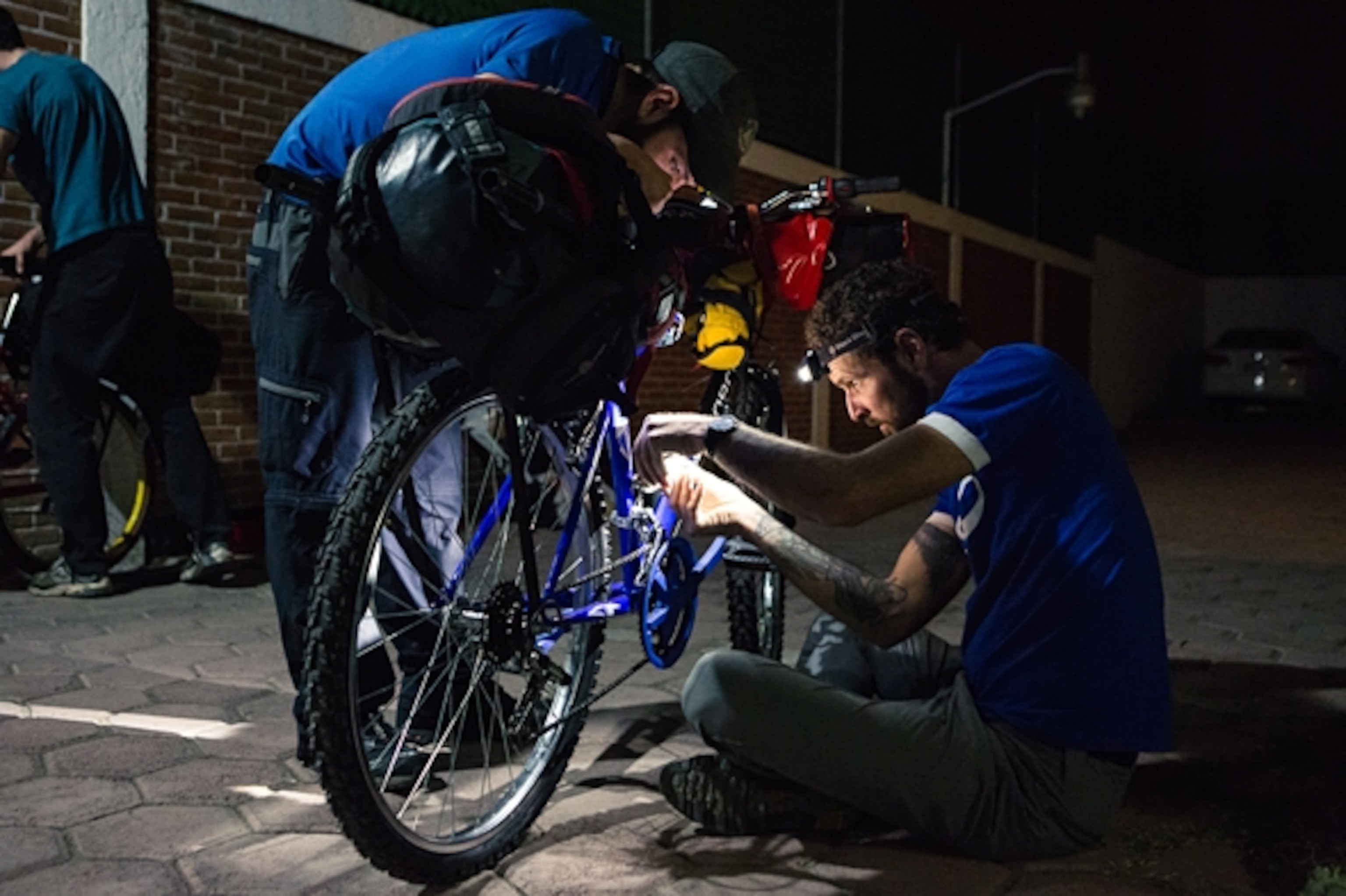 Steve Fassbinder adjusts the derailleur on Todd Tumolo's "Look Rich" brand bicycle; Photograph by Jim Harris