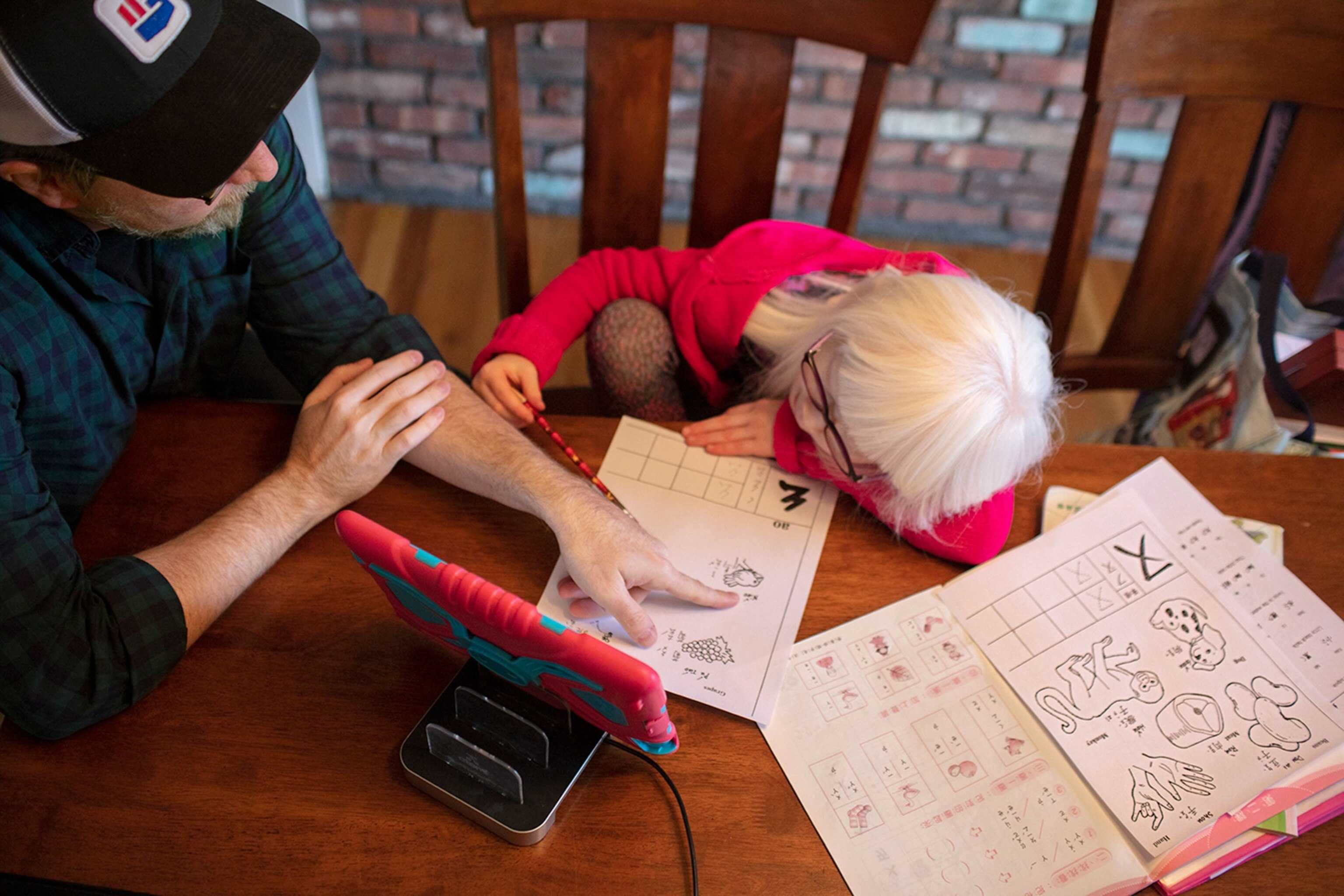a man helping his daughter with her homework
