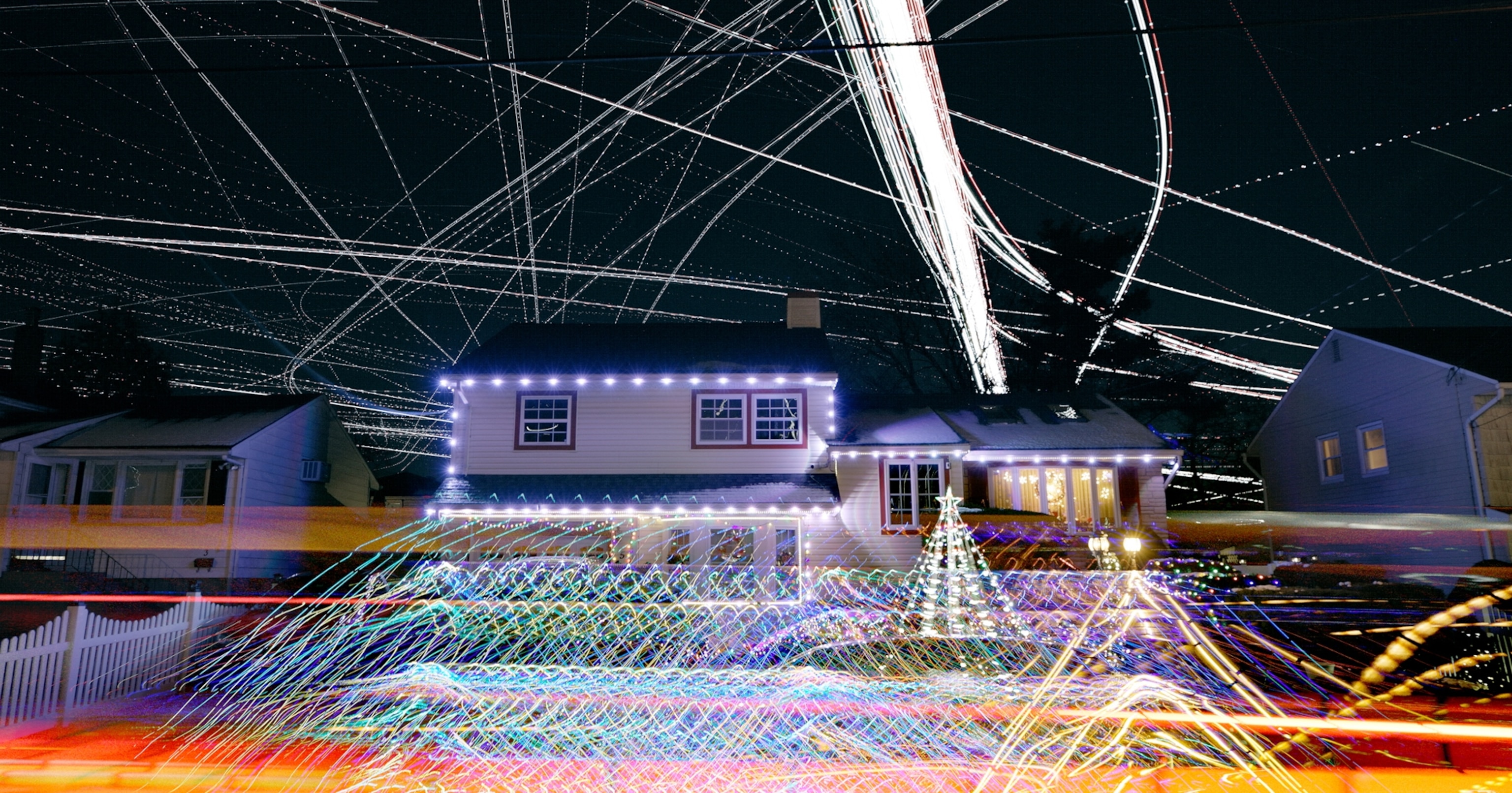 A house is surrounded by streaks of light in the sky.