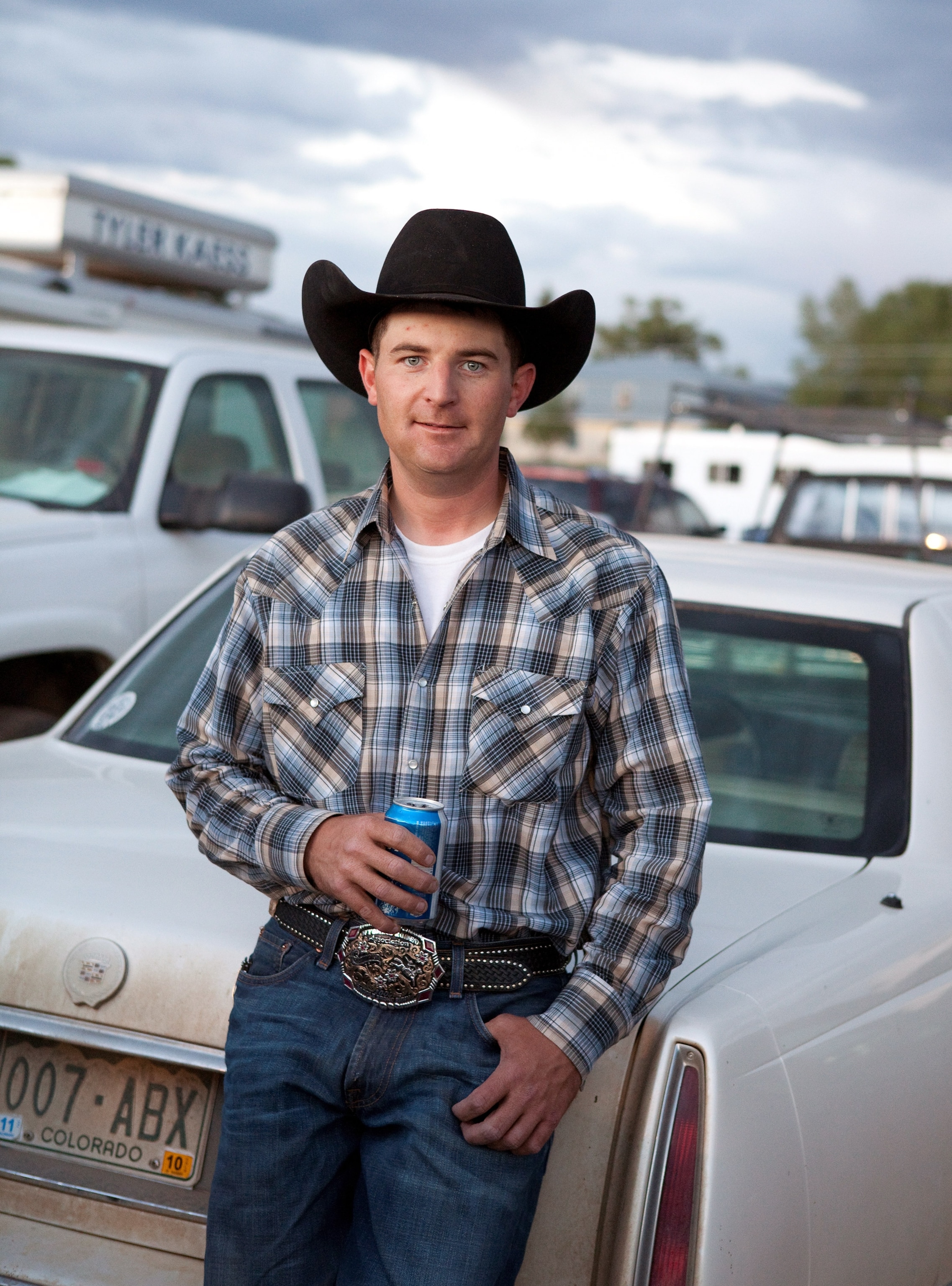 a man wearing a plaid shirt at a rodeo, Colorado