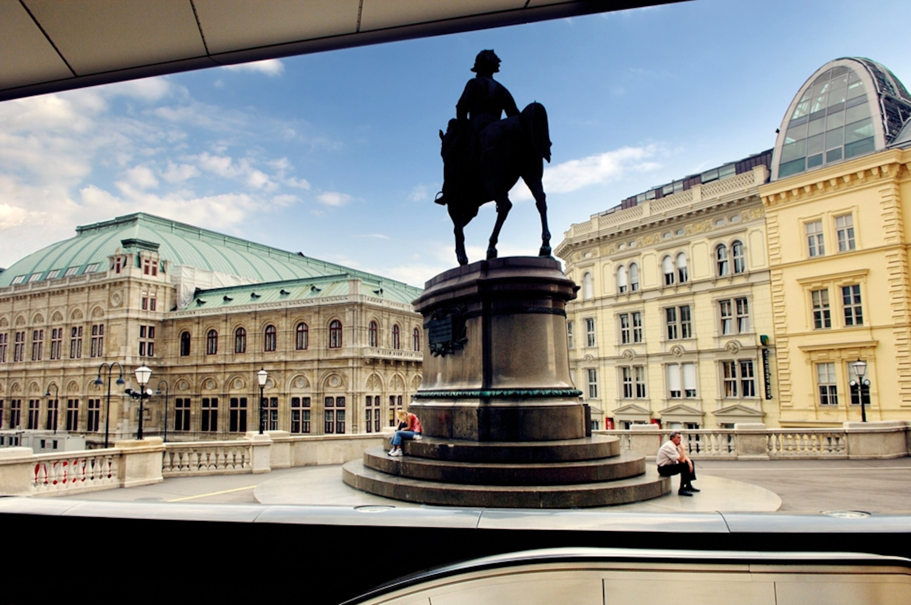 People sit near the Statue of Duke Albrecht in Vienna, Austria.