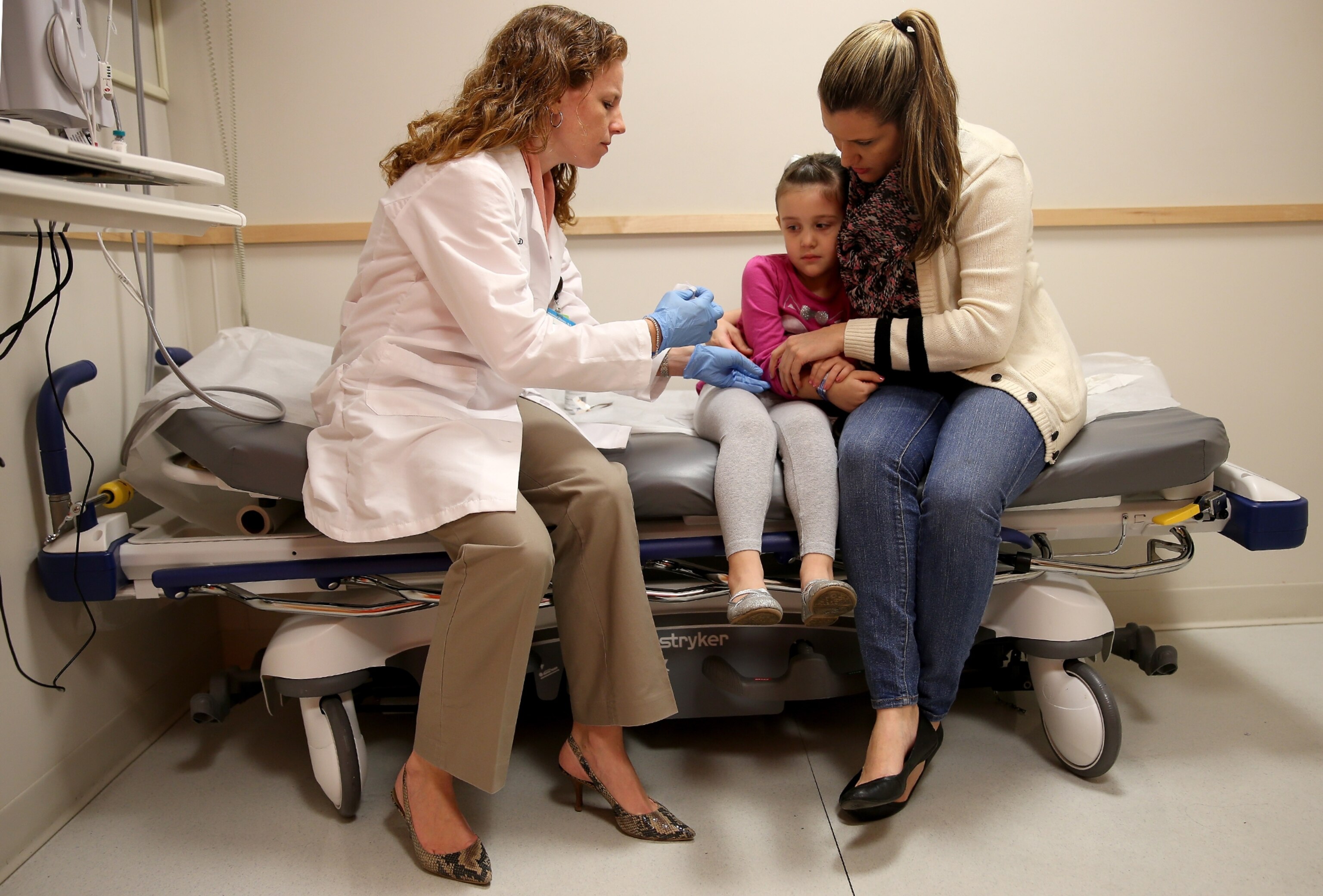 a doctor giving a measles vaccine to a child