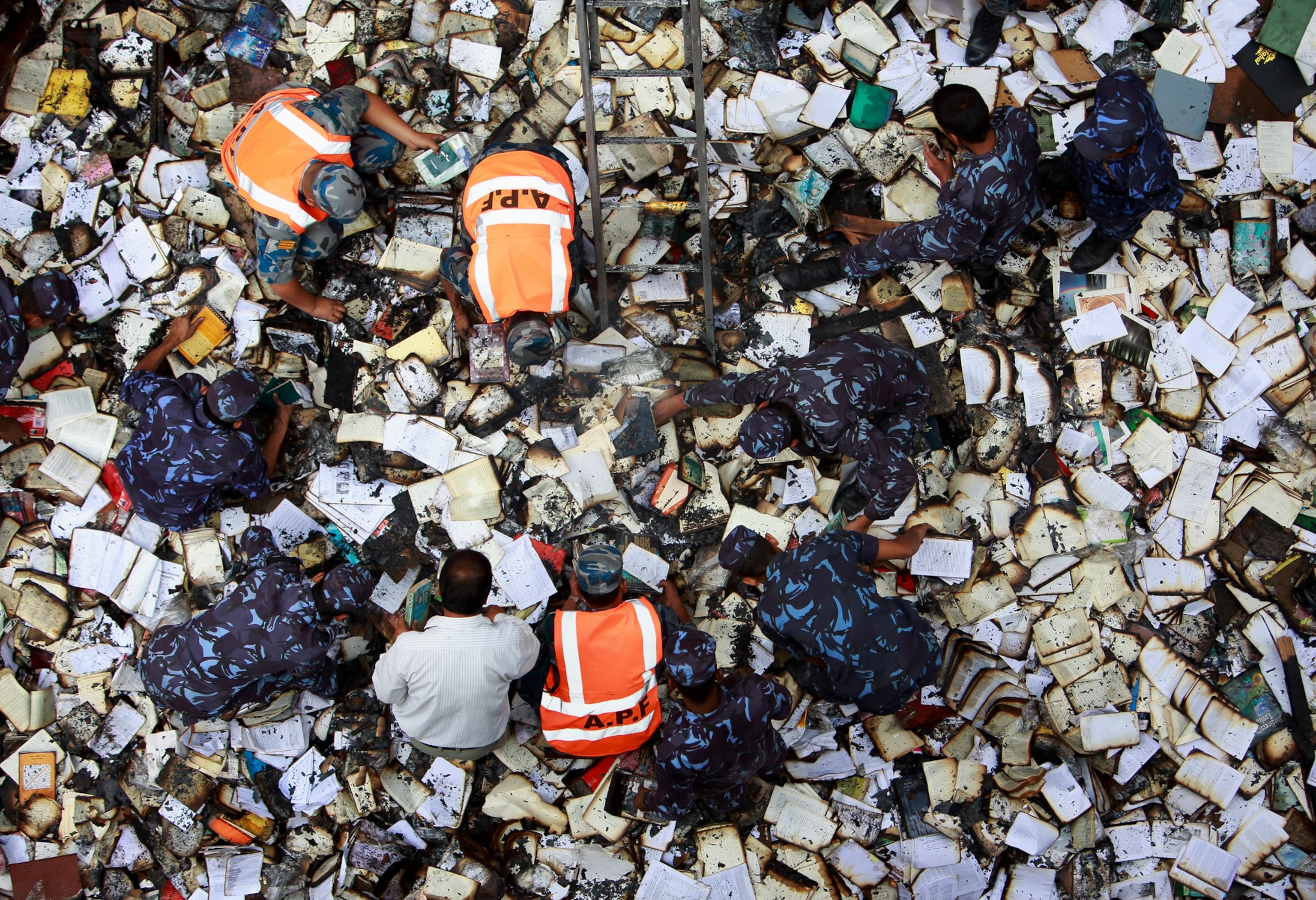 police looking through burnt books in Nepal