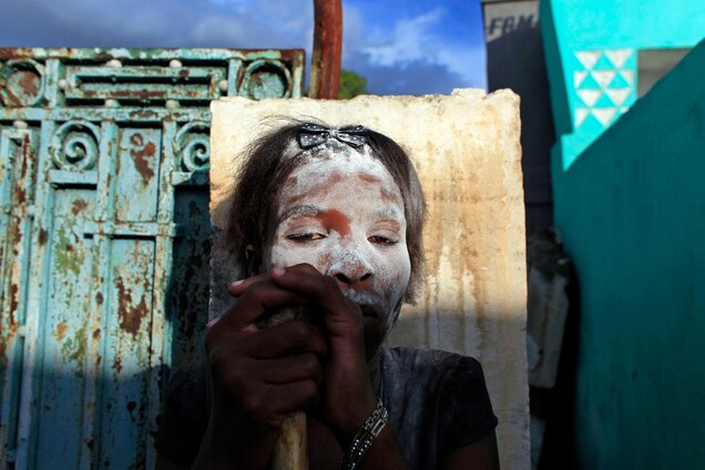 <p>On Gede, the Haitian Day of the Dead, voodoo believers paint their faces and wear purple and black to dress like spirits. Spicy rum is poured across gravestones, bones are arranged throughout the cemetery, and voodoos gather on tombs to call upon Baron Samedi, the Gede master of the dead.</p>