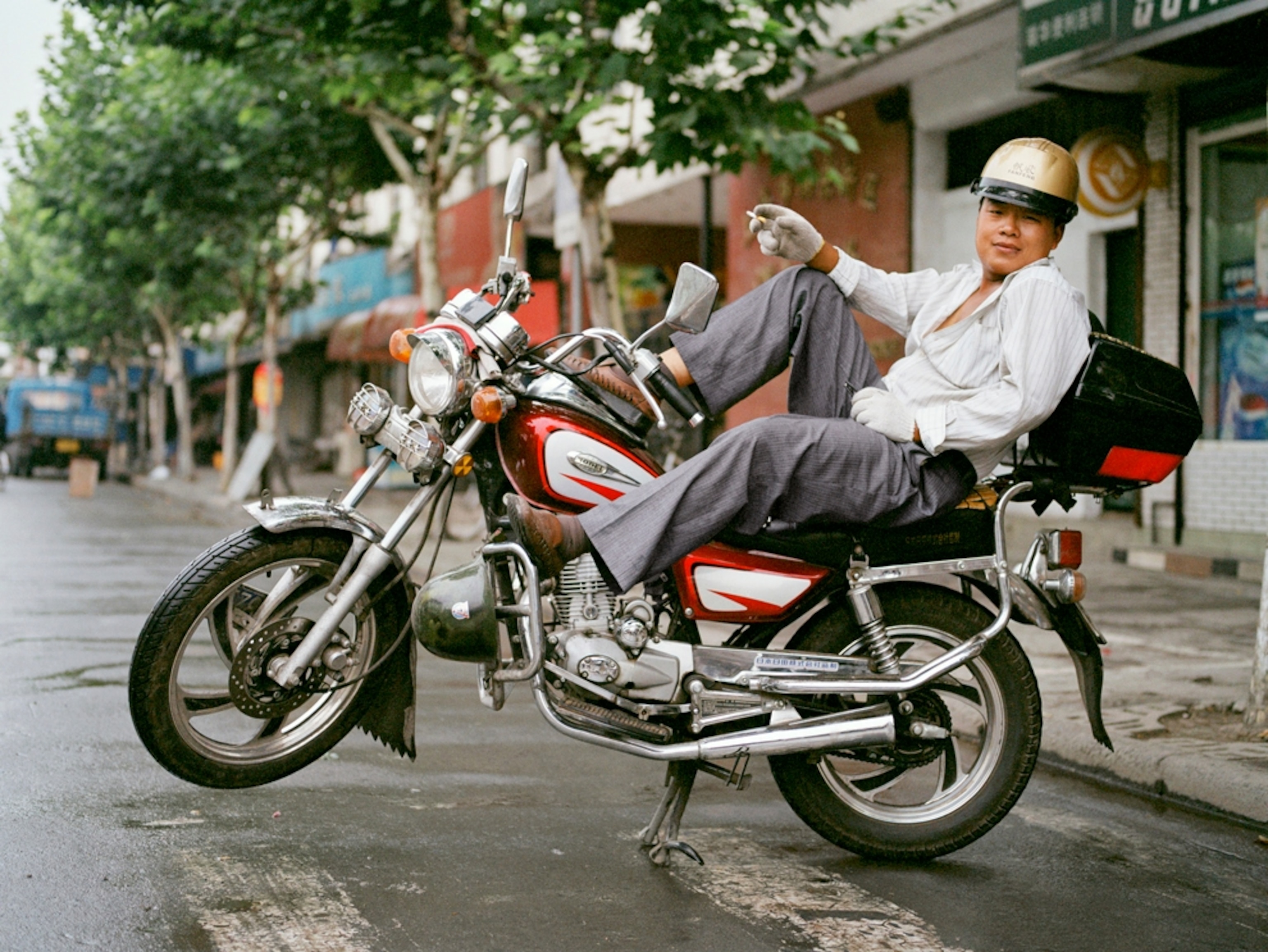 Man reclining on parked motorcycle