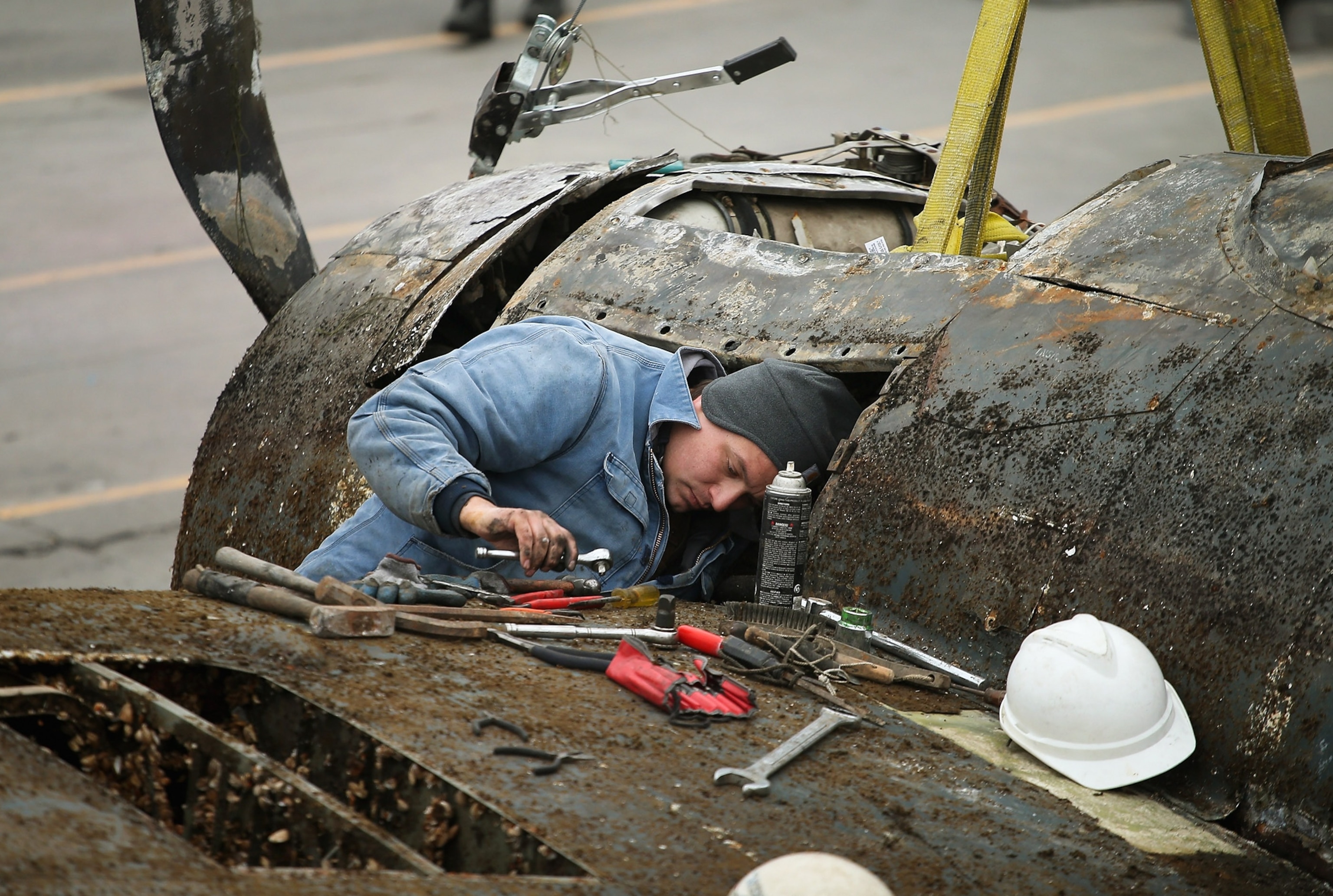 a worker prepping a Wildcat fighter recovered from Lake Michigan