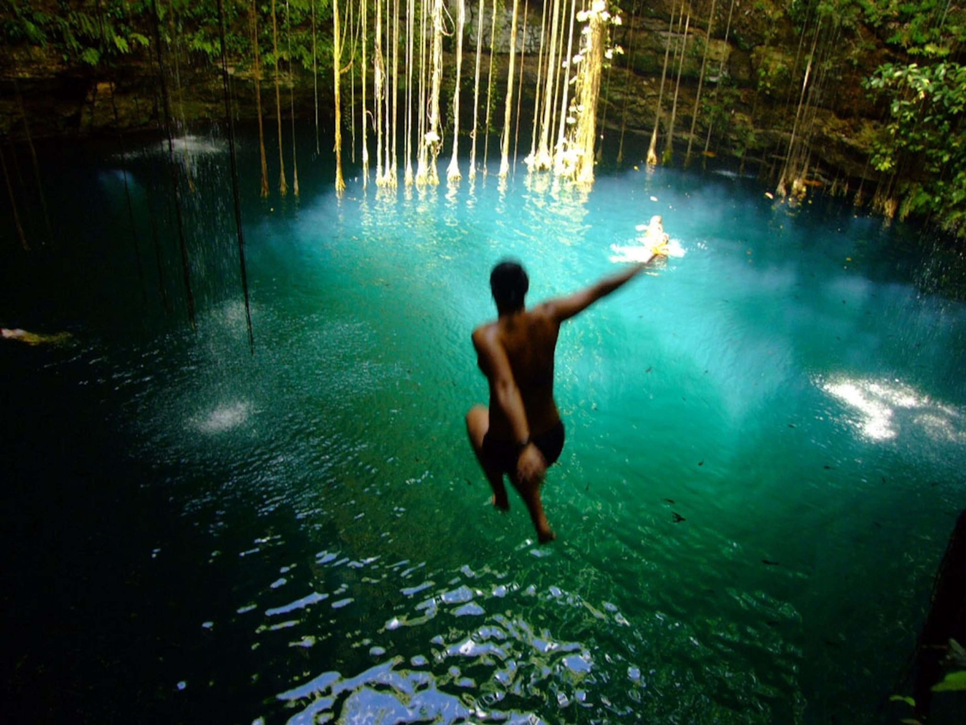 Woman jumping into a cenote in Quintana Roo, Mexico