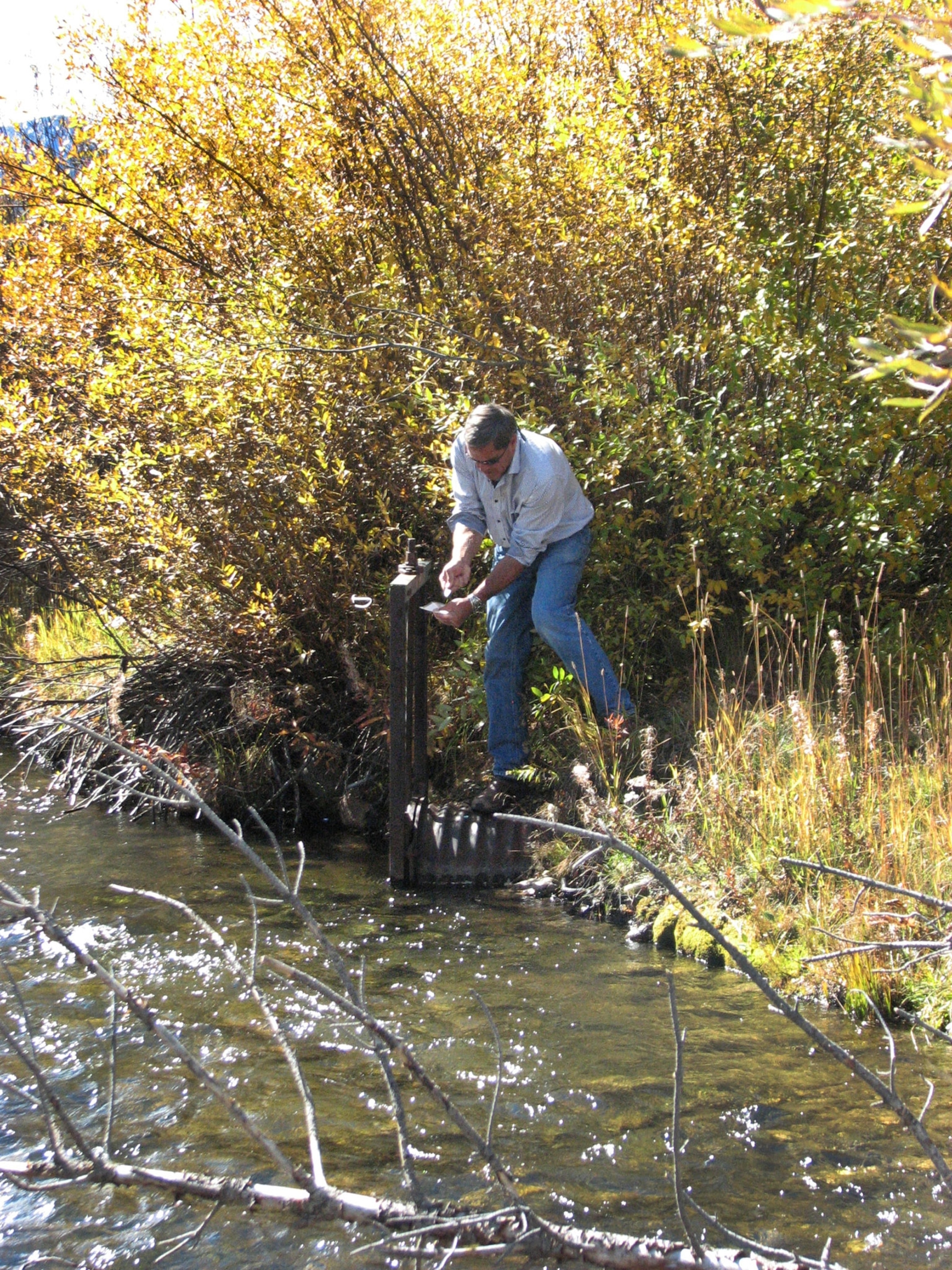 Pres. Dwight D. Eisenhower watching 7-yr-old grandson David fish as they stand at end of rickety pier, on Fraser River at Byers Peak Ranch.