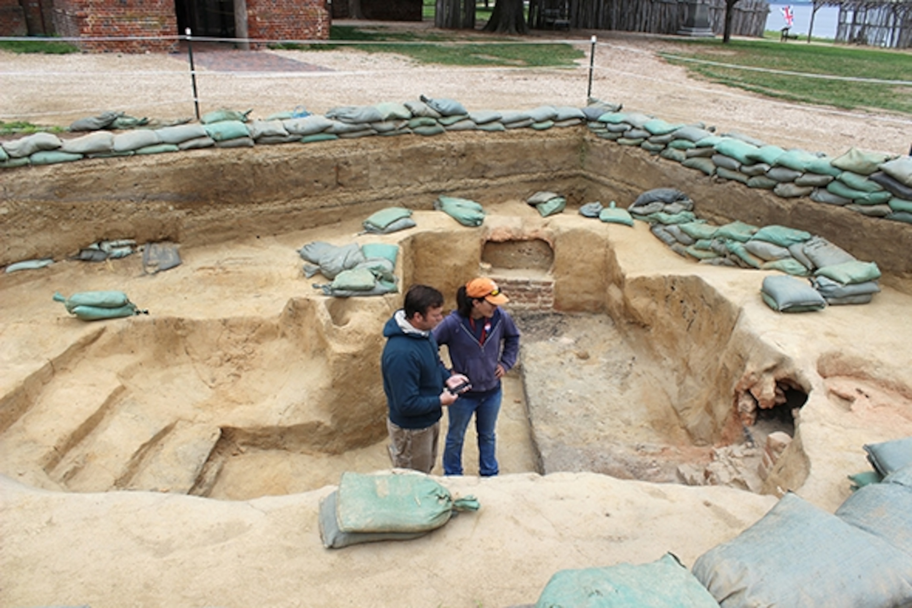 Archaeologists Mary Anna Richardson and Dave Givens stand in a dig site at Historic Jamestowne. (Photograph by Annie Fitzsimmons)