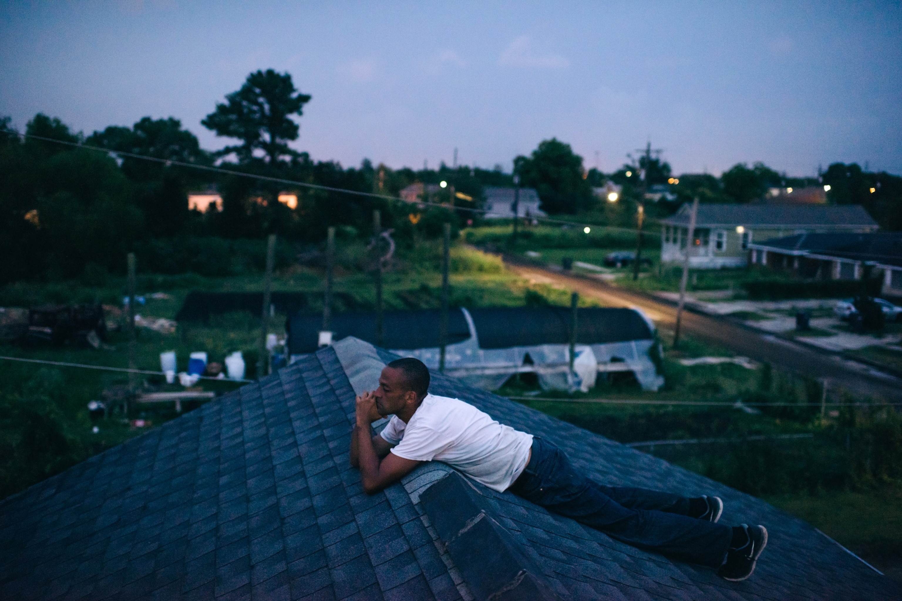 Turner sits on the roof of the farm's main building. He aims to build a sustainable farm that will provide jobs for people in the community.
