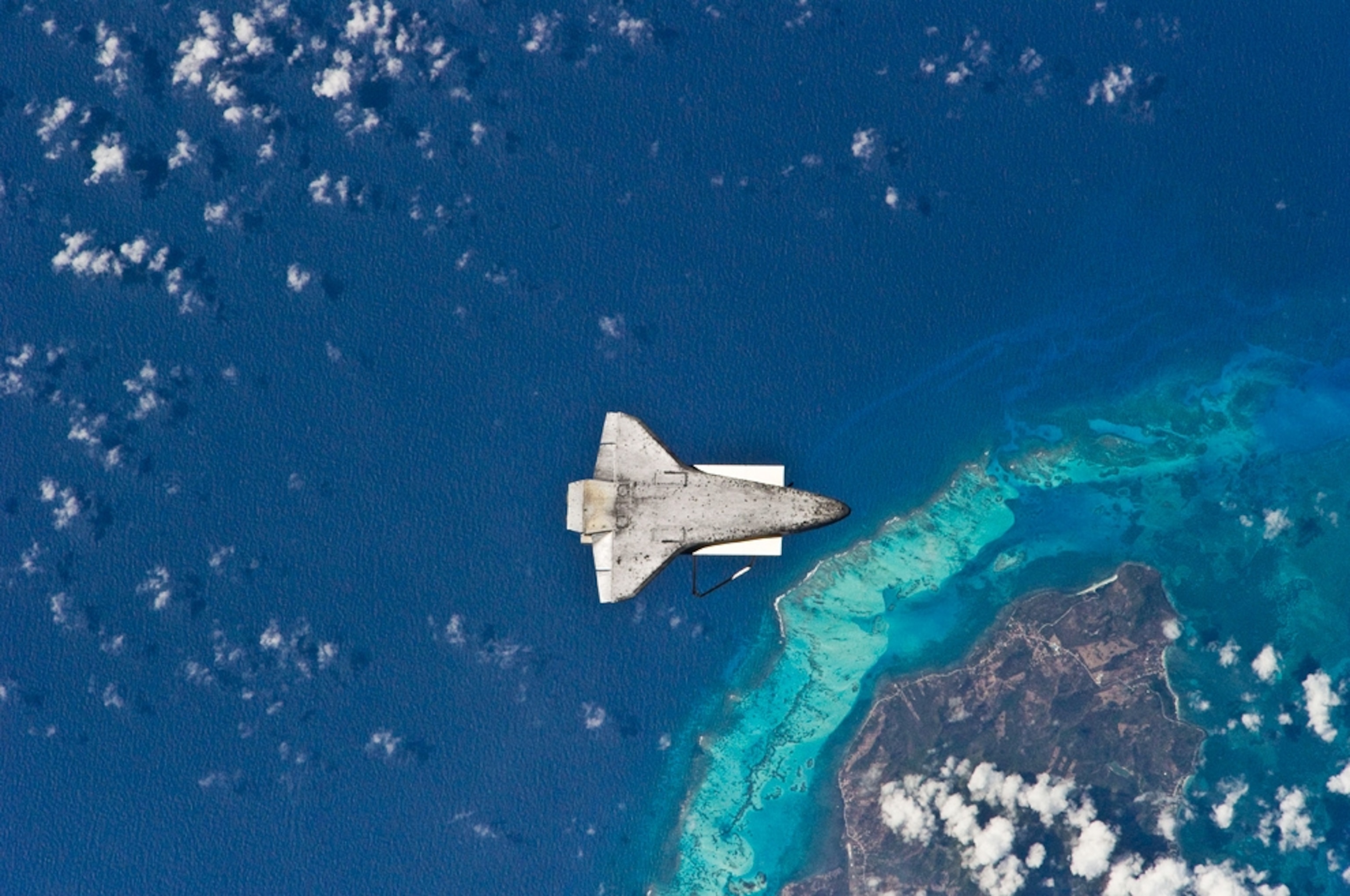 An astronaut's picture of the underside of the space shuttle, with Earth as a backdrop.