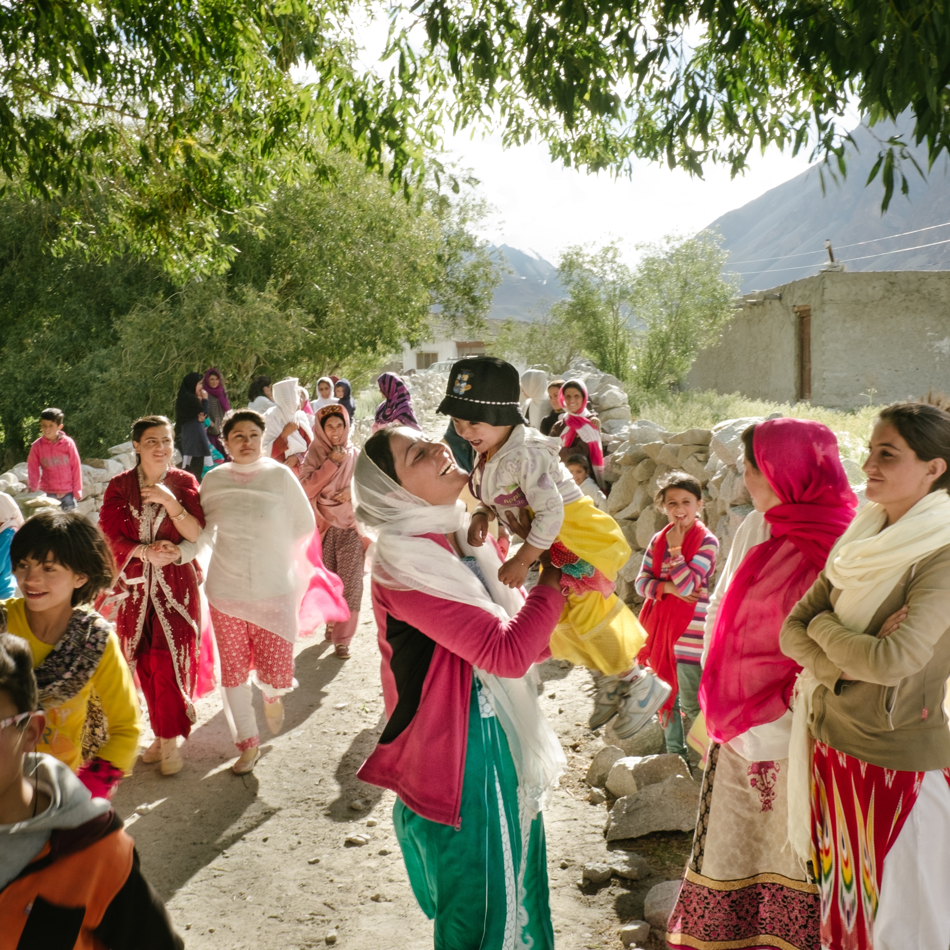 A wedding celebration in the Chapursan Valley shows women and children smiling and laughing together.