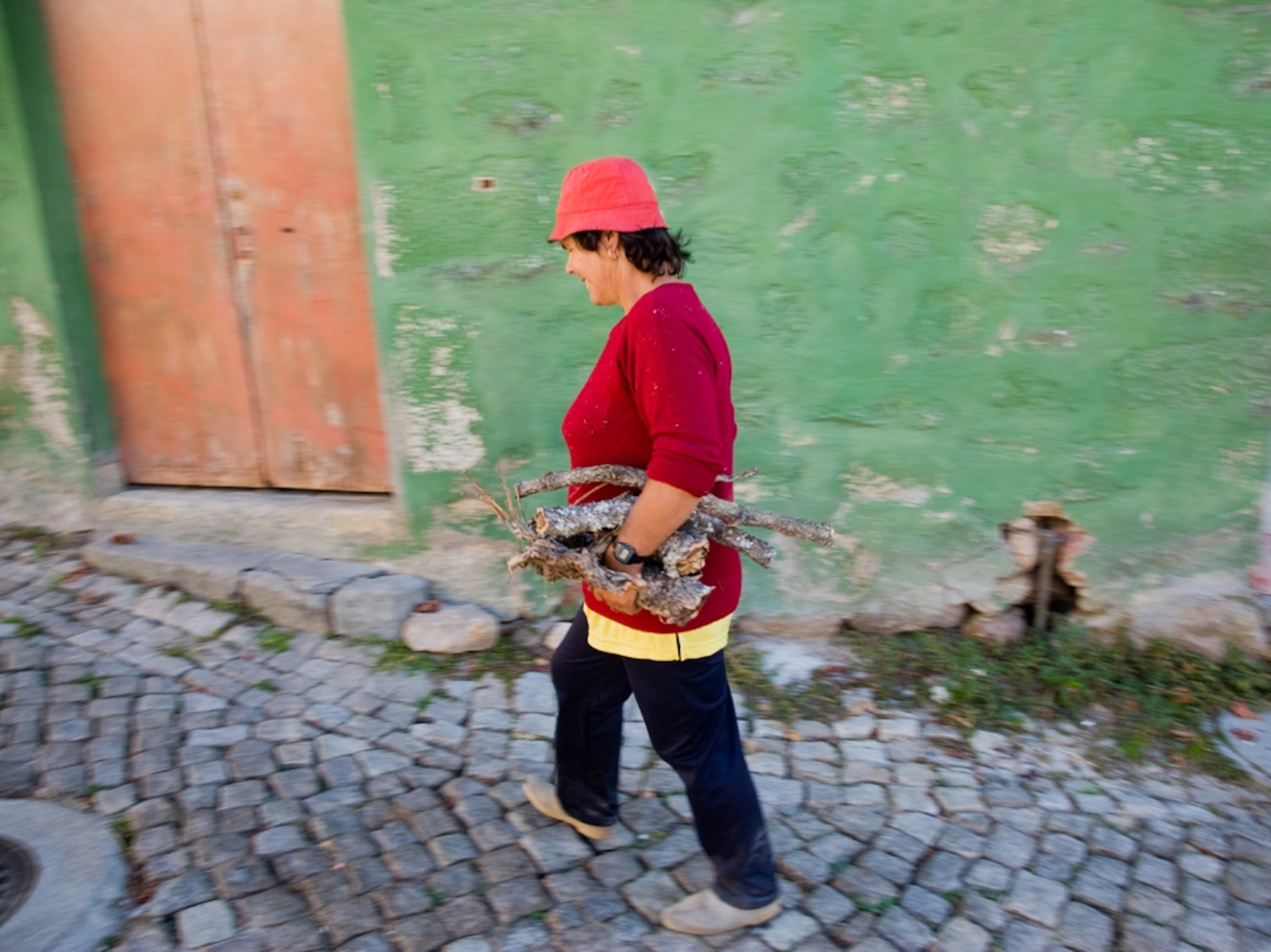 Local woman walking stone street, Portugal