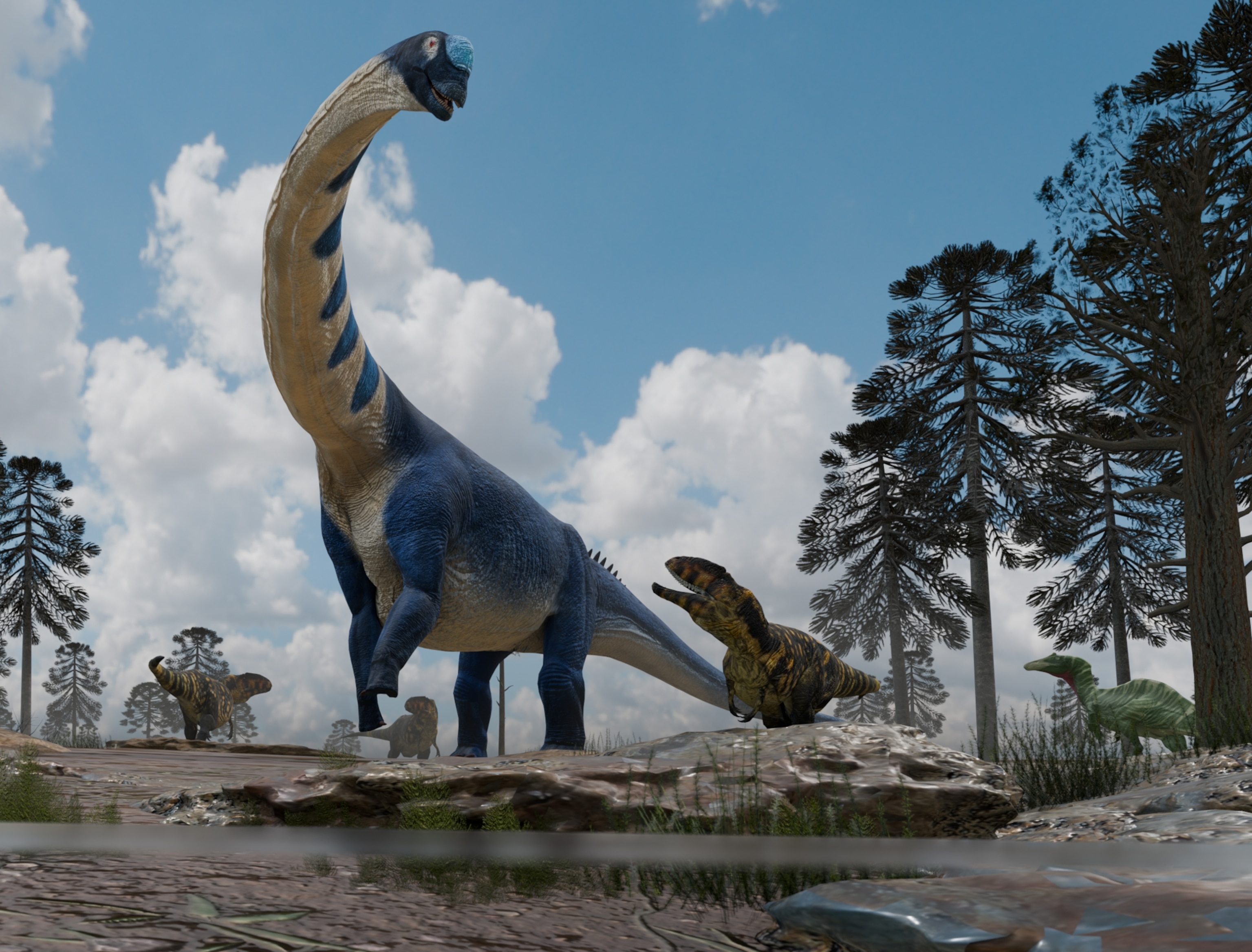 Dinosaurs roam a prehistoric landscape under a bright blue sky. Tall trees tower around a massive, blue titanosaur