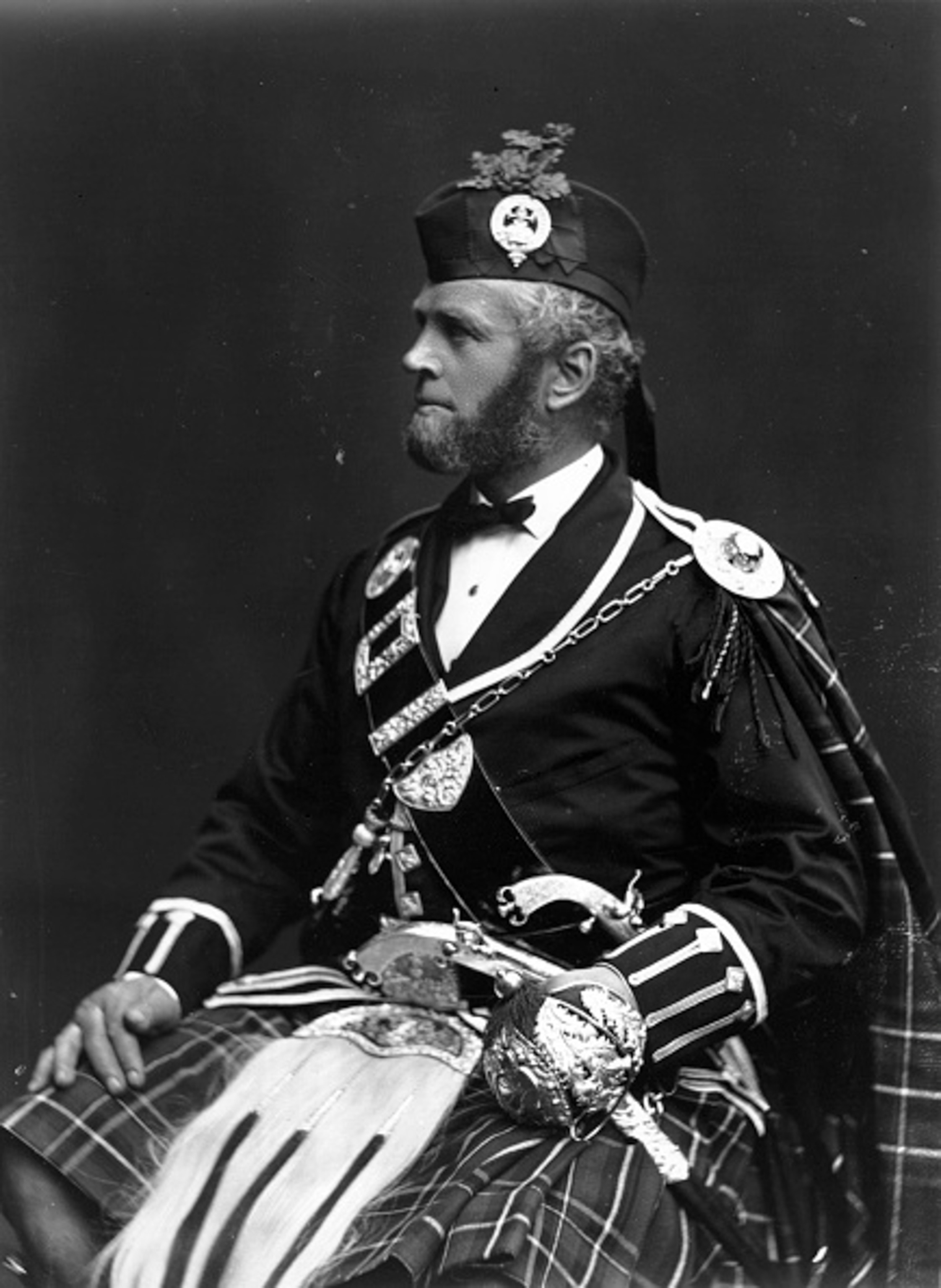 A man is photographed on a dark background in black and white.