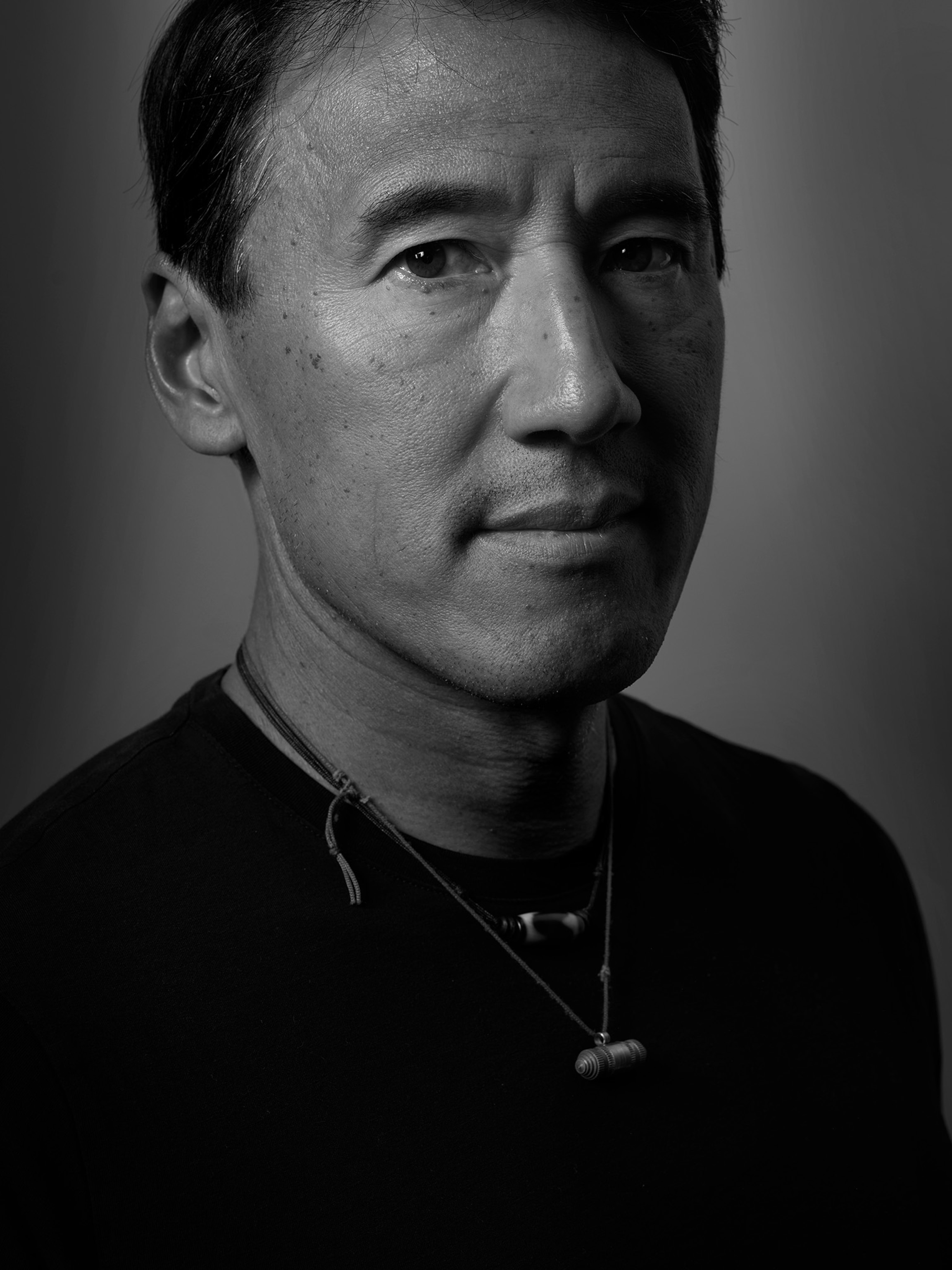 Black and white portrait of a person whose face is half lit