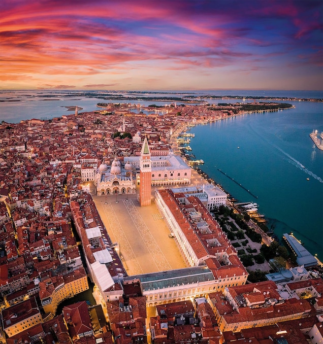 An aerial view of Venice reveals the serenity of its waterways that embrace the lands around the main square, St. Mark&rsquo;s Basilica, and its Campanile.