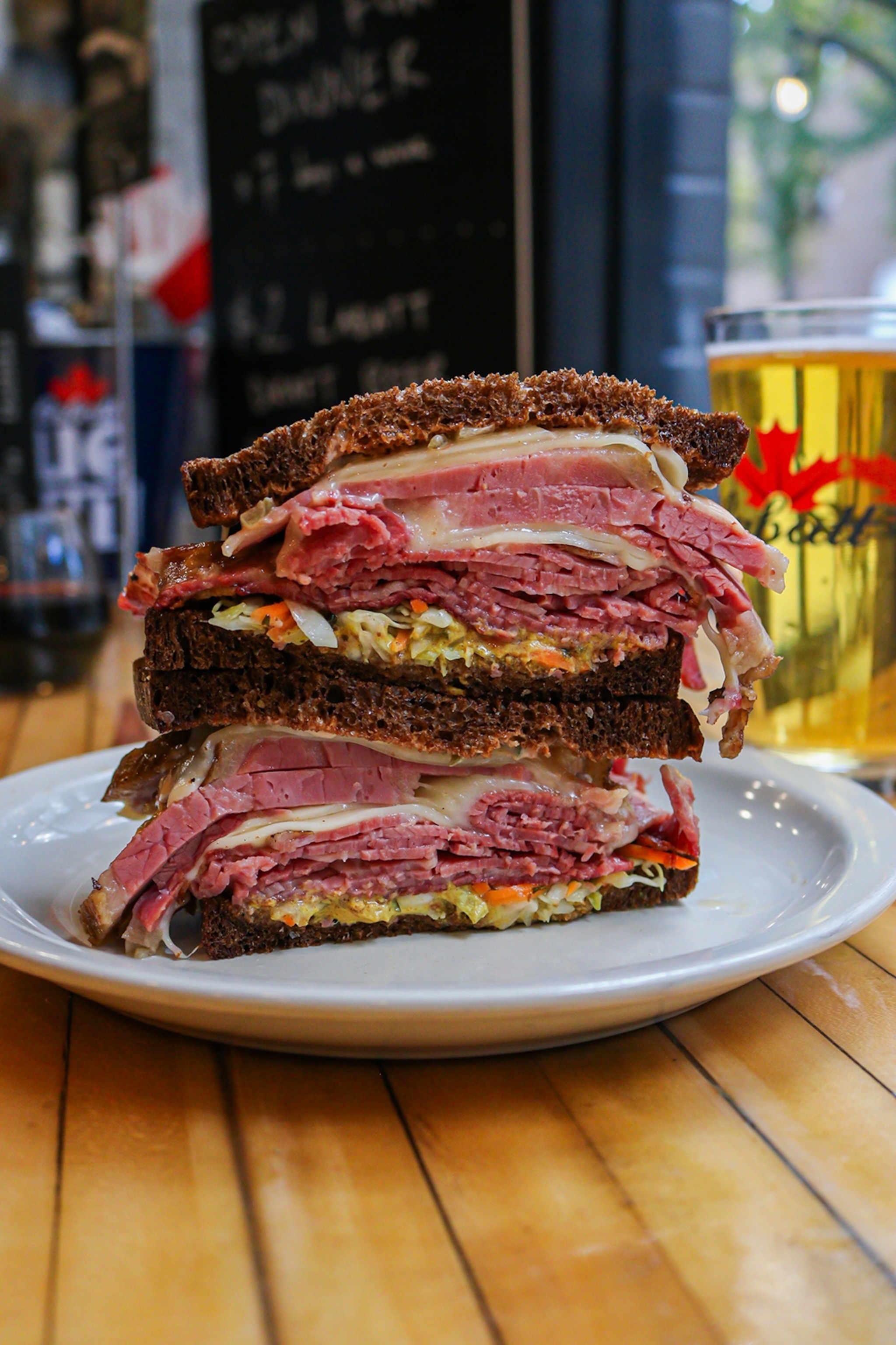 A stacked pumpernickel rye sandwich cut in half, revealing layers of roasted turkey.