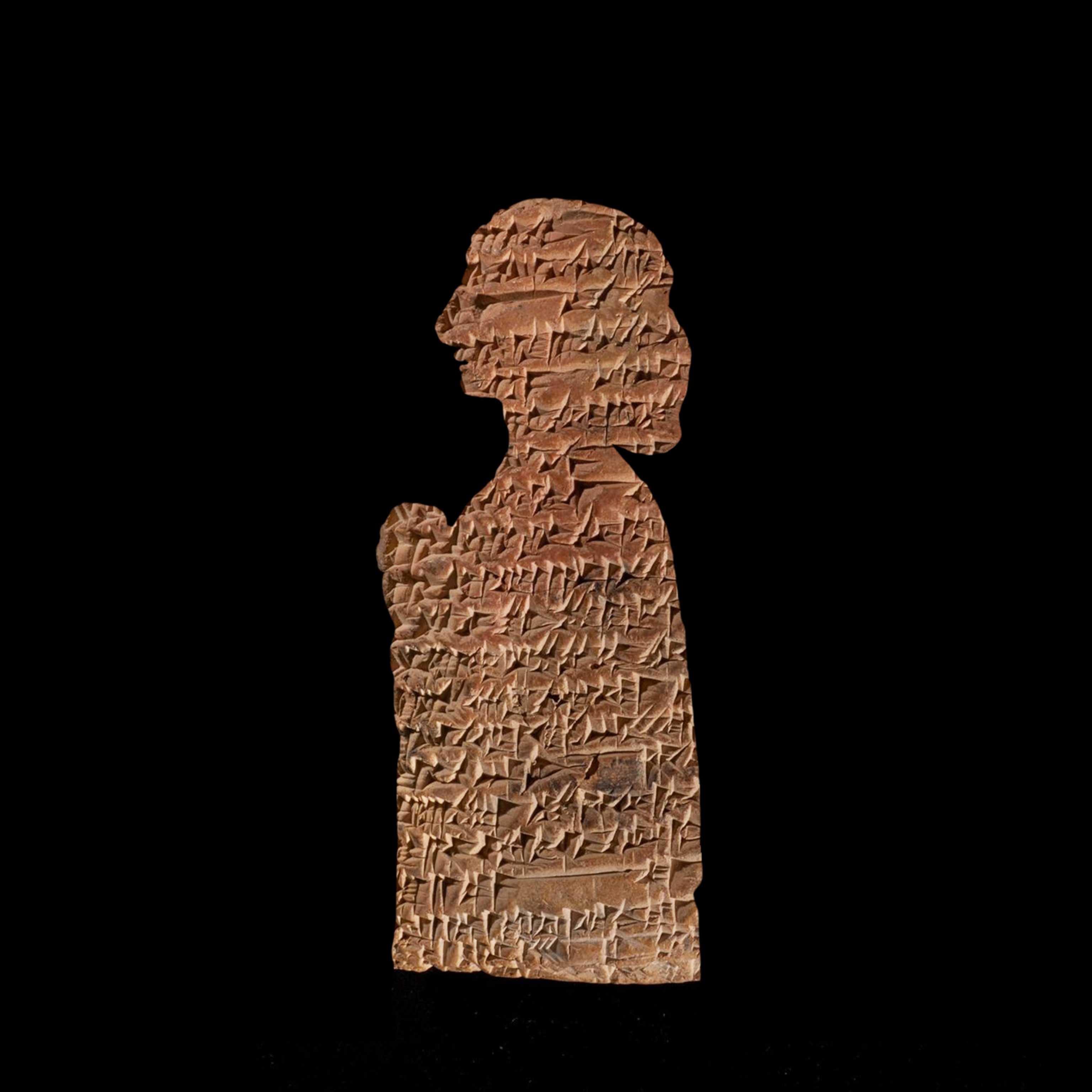 The profile of a female statue outlined in black, filled with a clay tablet