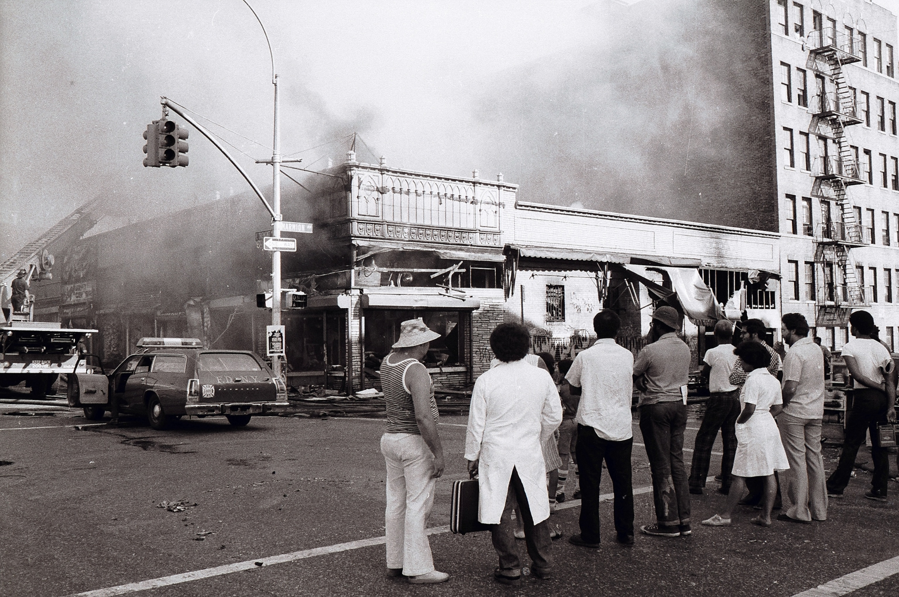 New York blackout picture - people watch as firefighters put out an arson fire on Marmion Avenue in the Bronx during the aftermath of the blackout of 1977