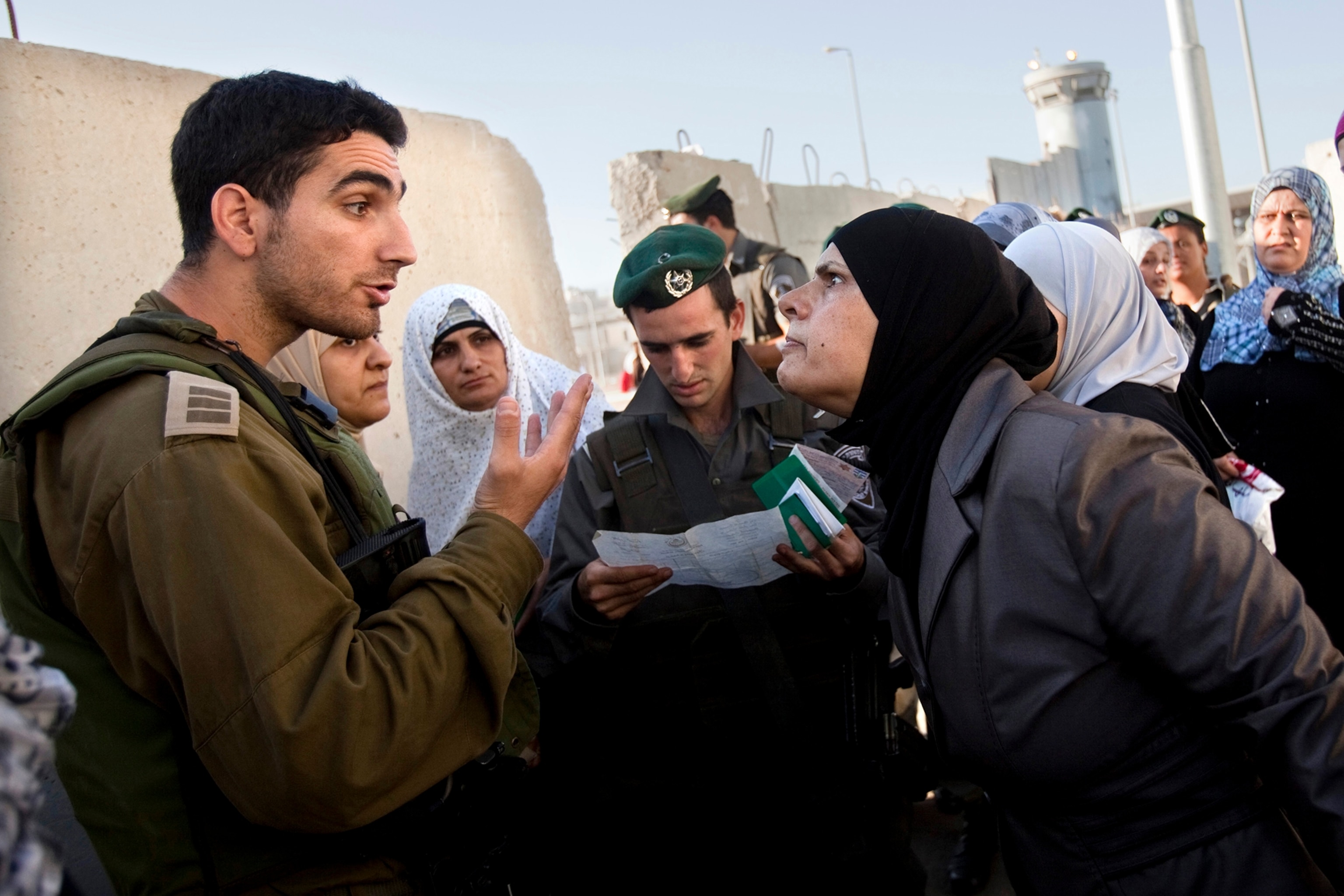 A Palestinian woman argues with Israeli border police while waiting to cross into Israel.
