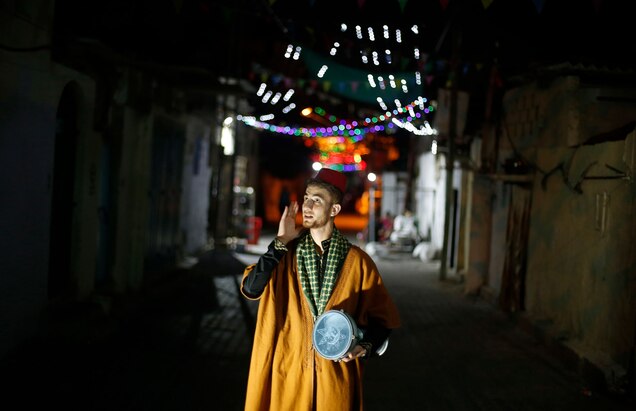 a man walks through streets with a drum