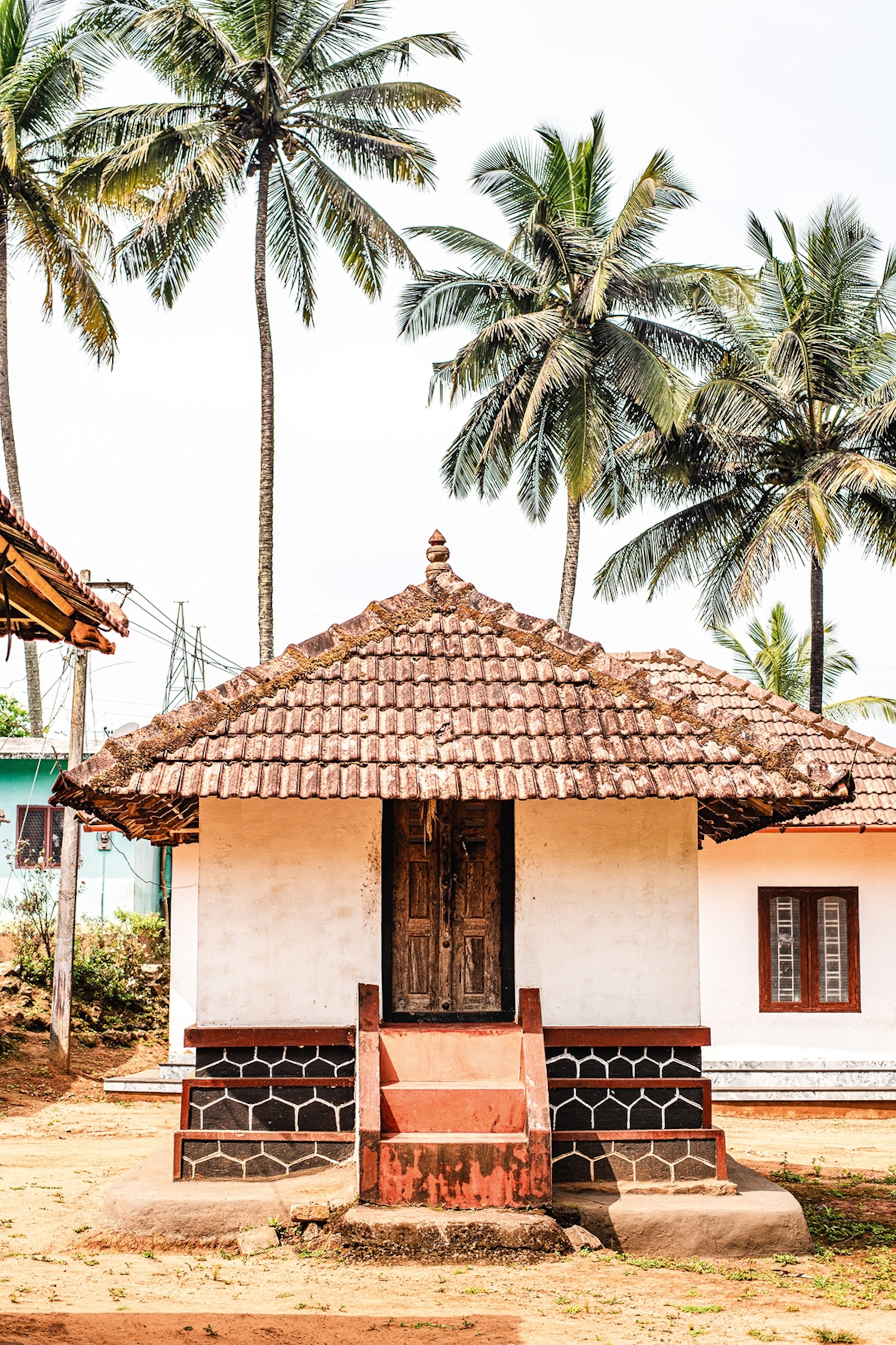 A simple, small hut with three steps leading up to the front door.