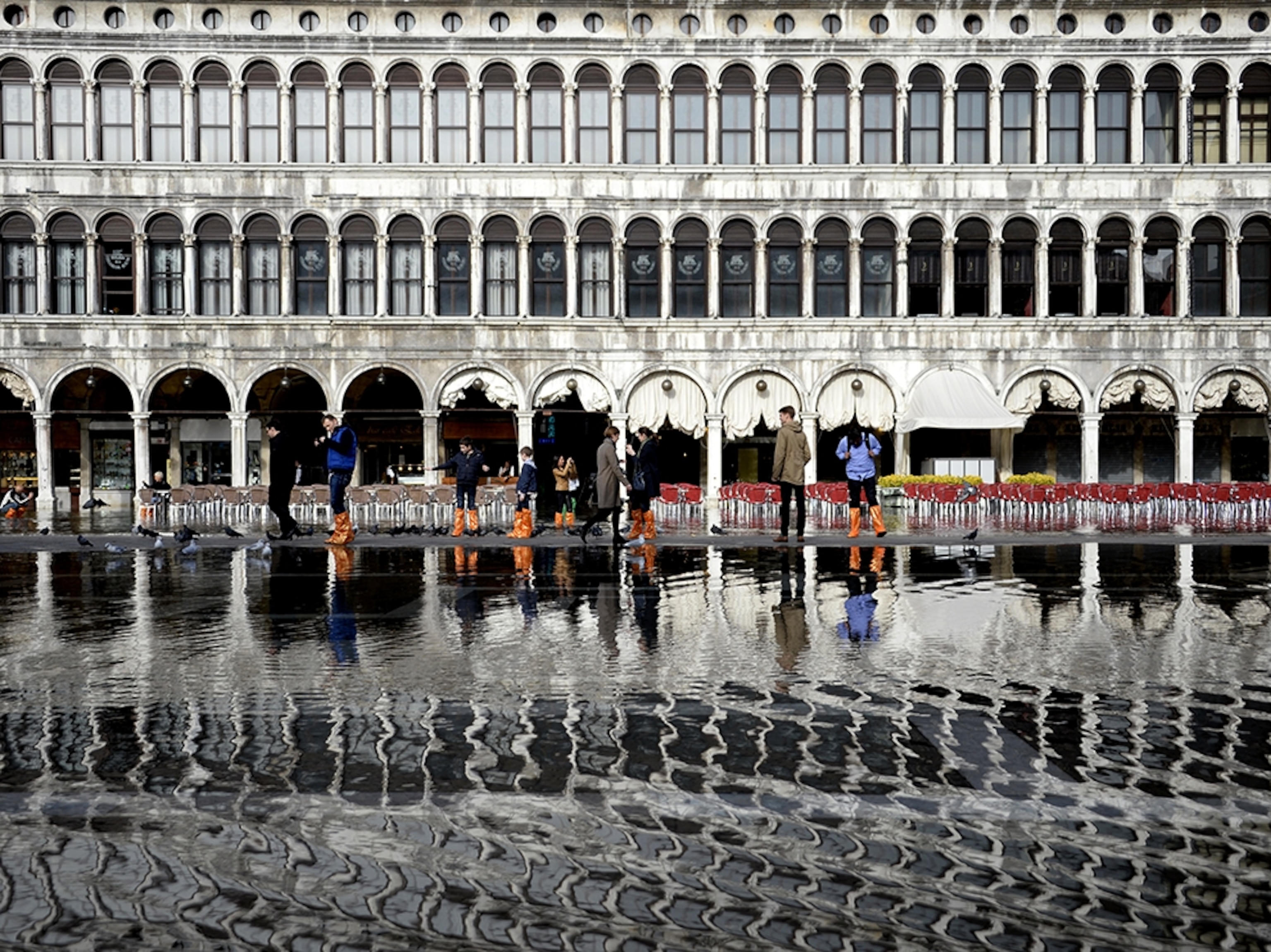 tourists standing in flooded Piazza San Marco in Venice, Italy