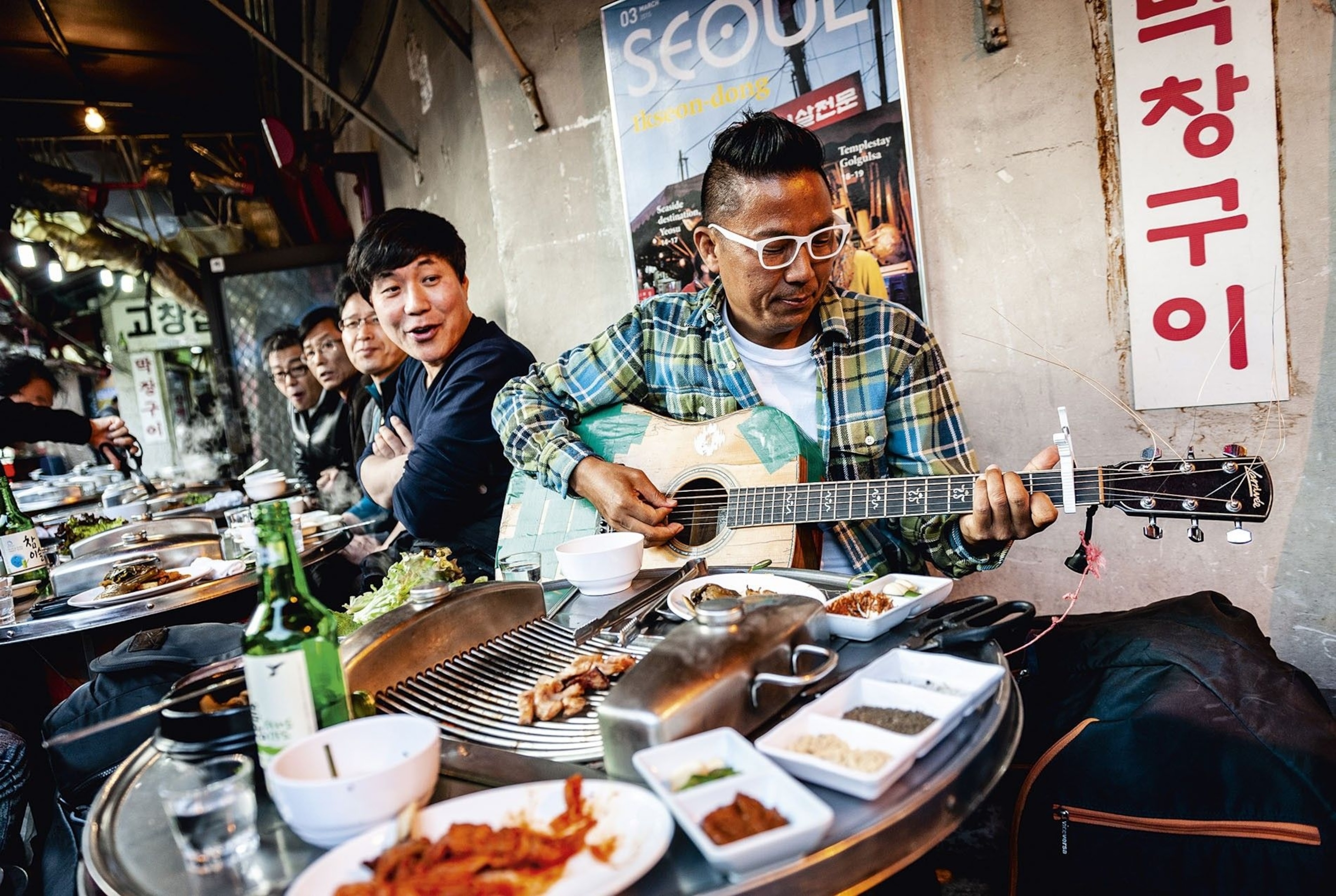 Musician playing the guitar outside Mi Galmaegisal BBQ restaurant in Jongno-gu district.