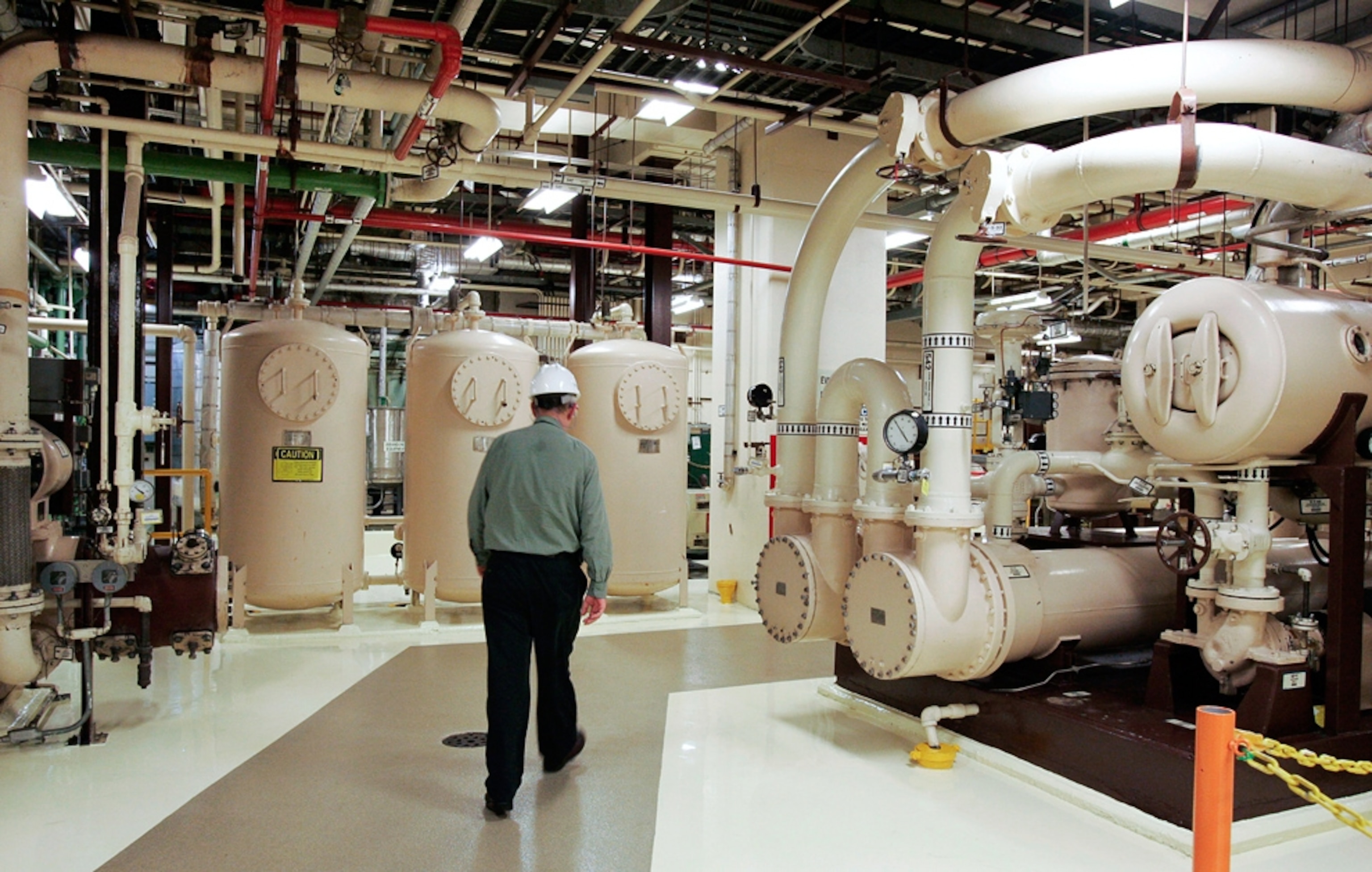 An Exelon employee walks past equipment in the turbine building at the Oyster Creek nuclear plant in Lacey Township, N.J.