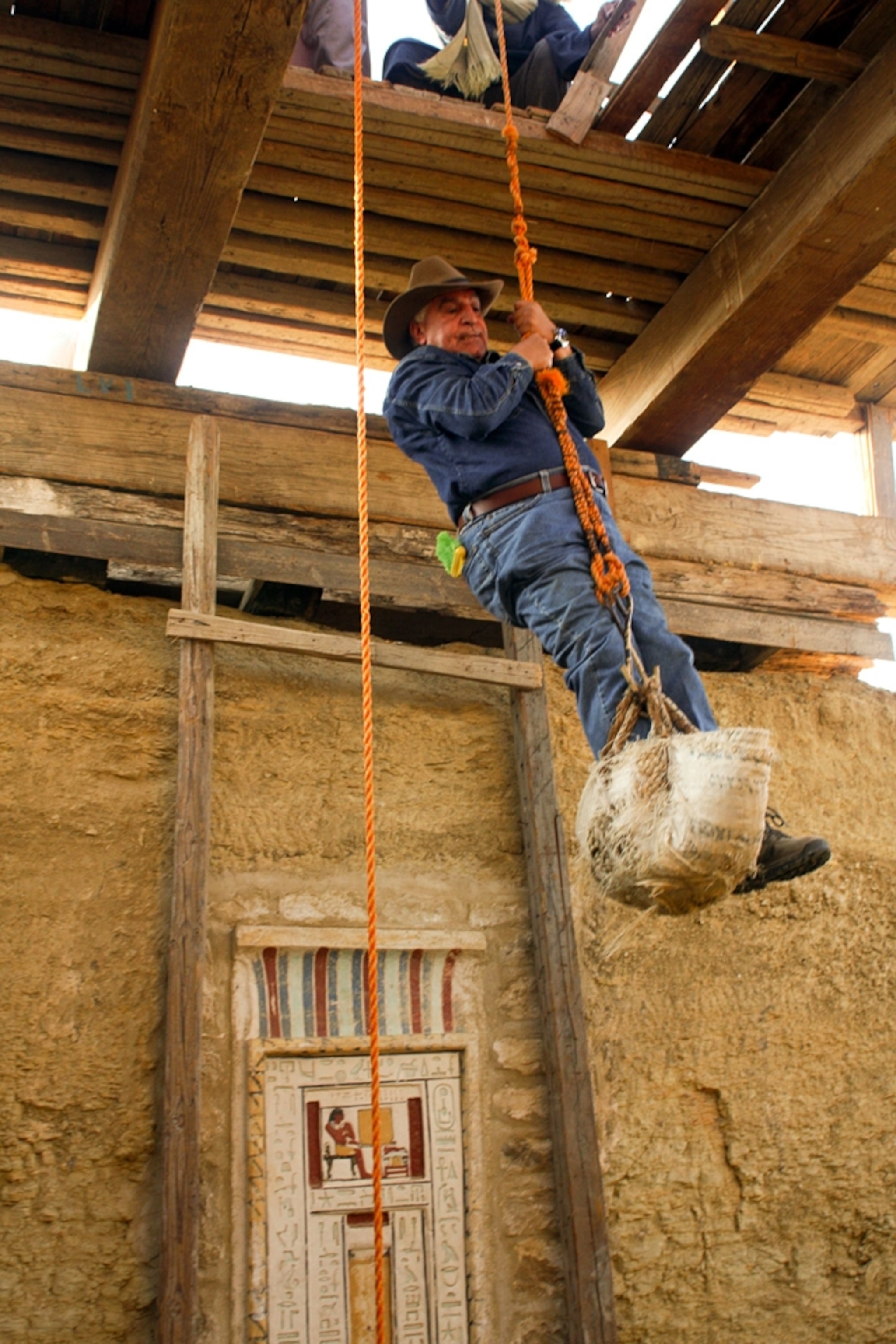 Egypt antiquities chief Zahi Hawass being lowered into the ancient Egyptian tomb of Shendwa.