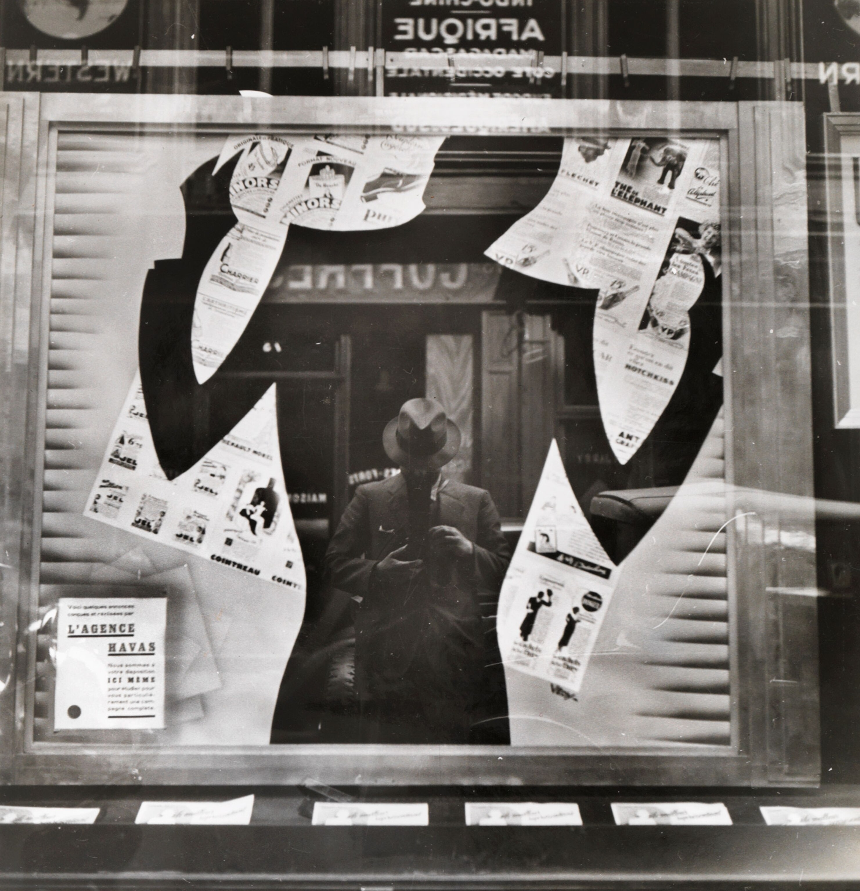 man's reflection in a shop window.