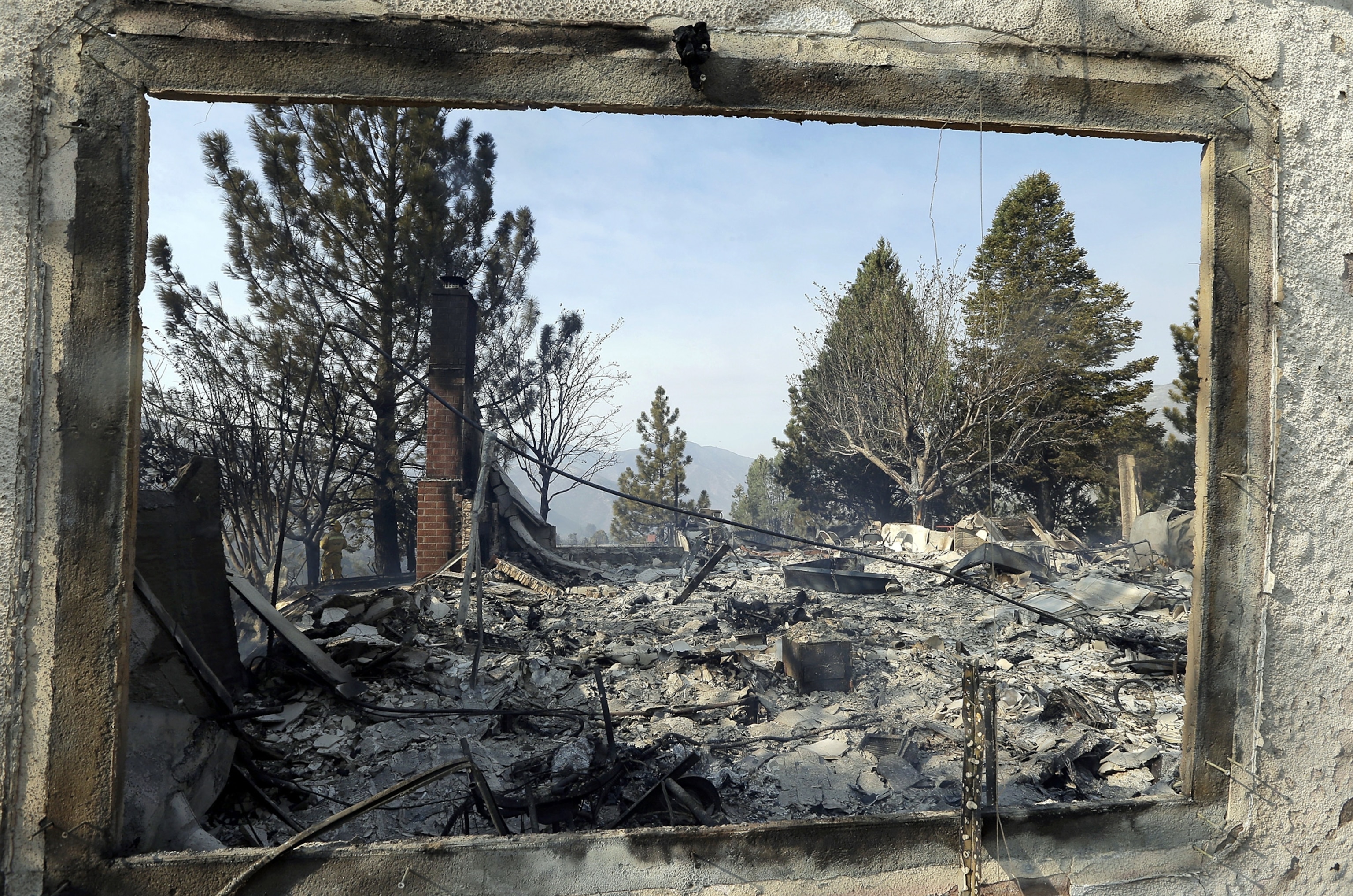 Picture of fire destruction through the window frame of a burned down home.