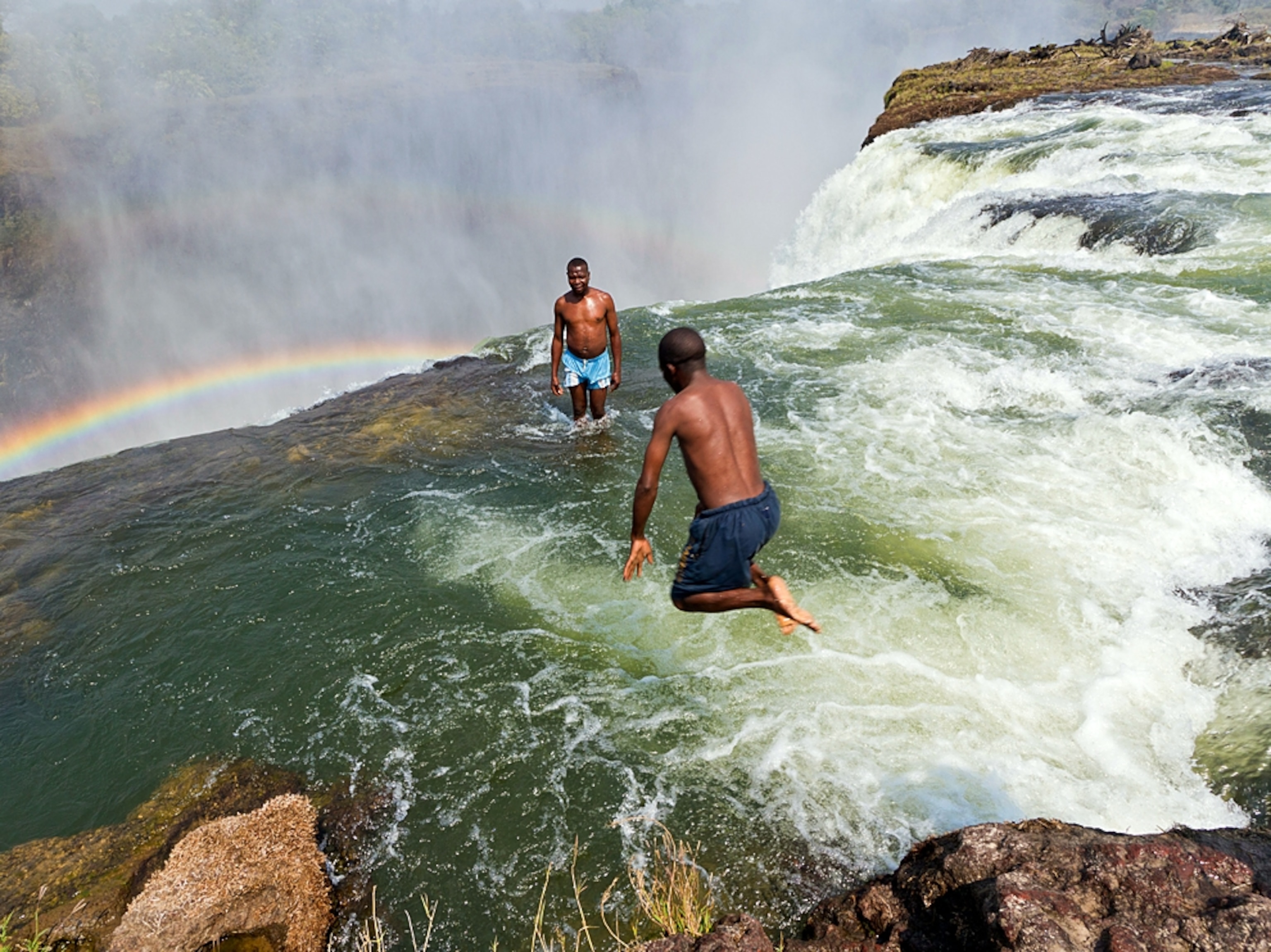 men in Devil's Pool at Victoria Falls, Zambia