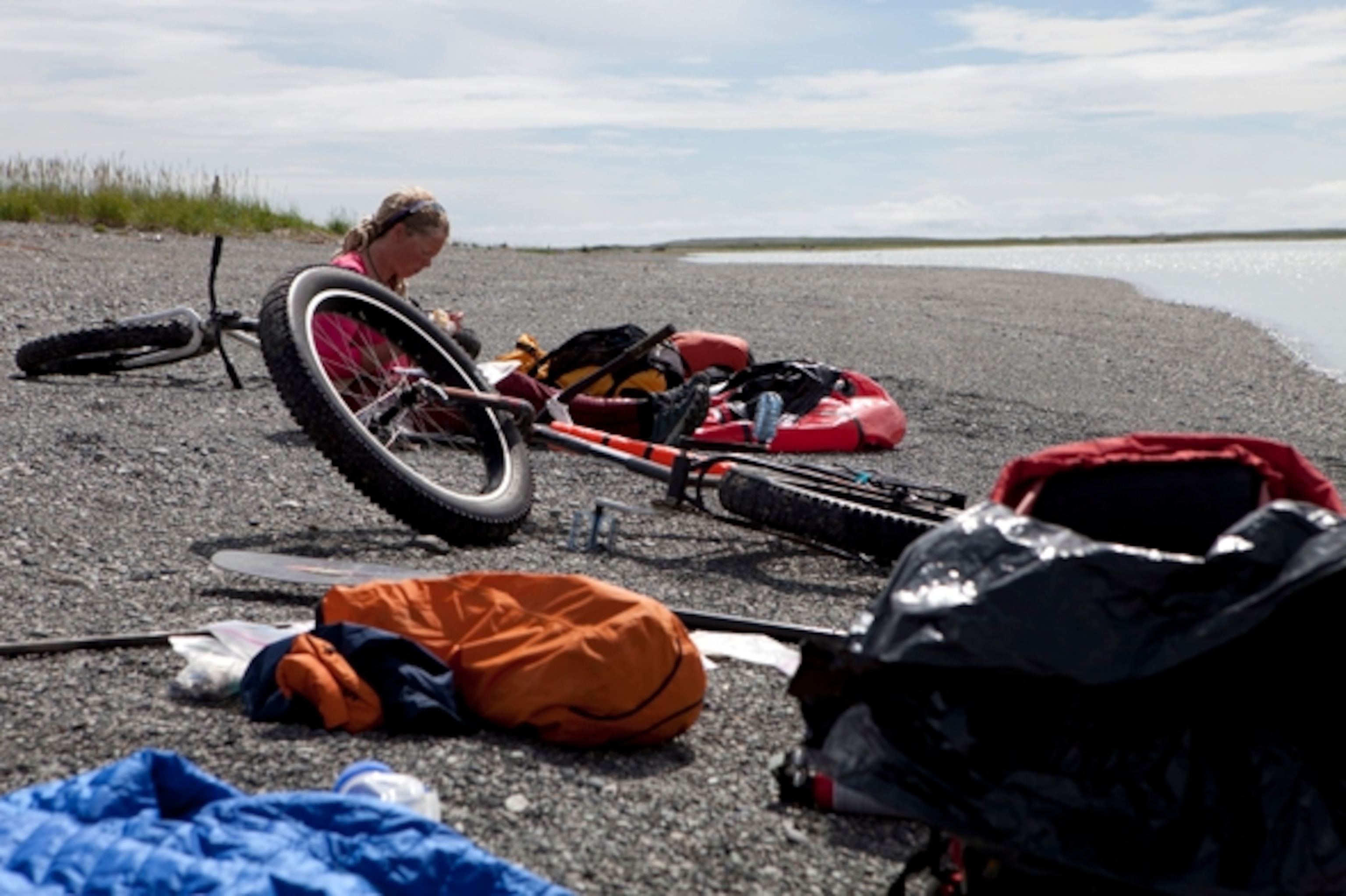 Safely on the other side of the Alsek, we spend some time soaking in the sun and relaxing on the pebble beach; Photograph by Cameron Lawson