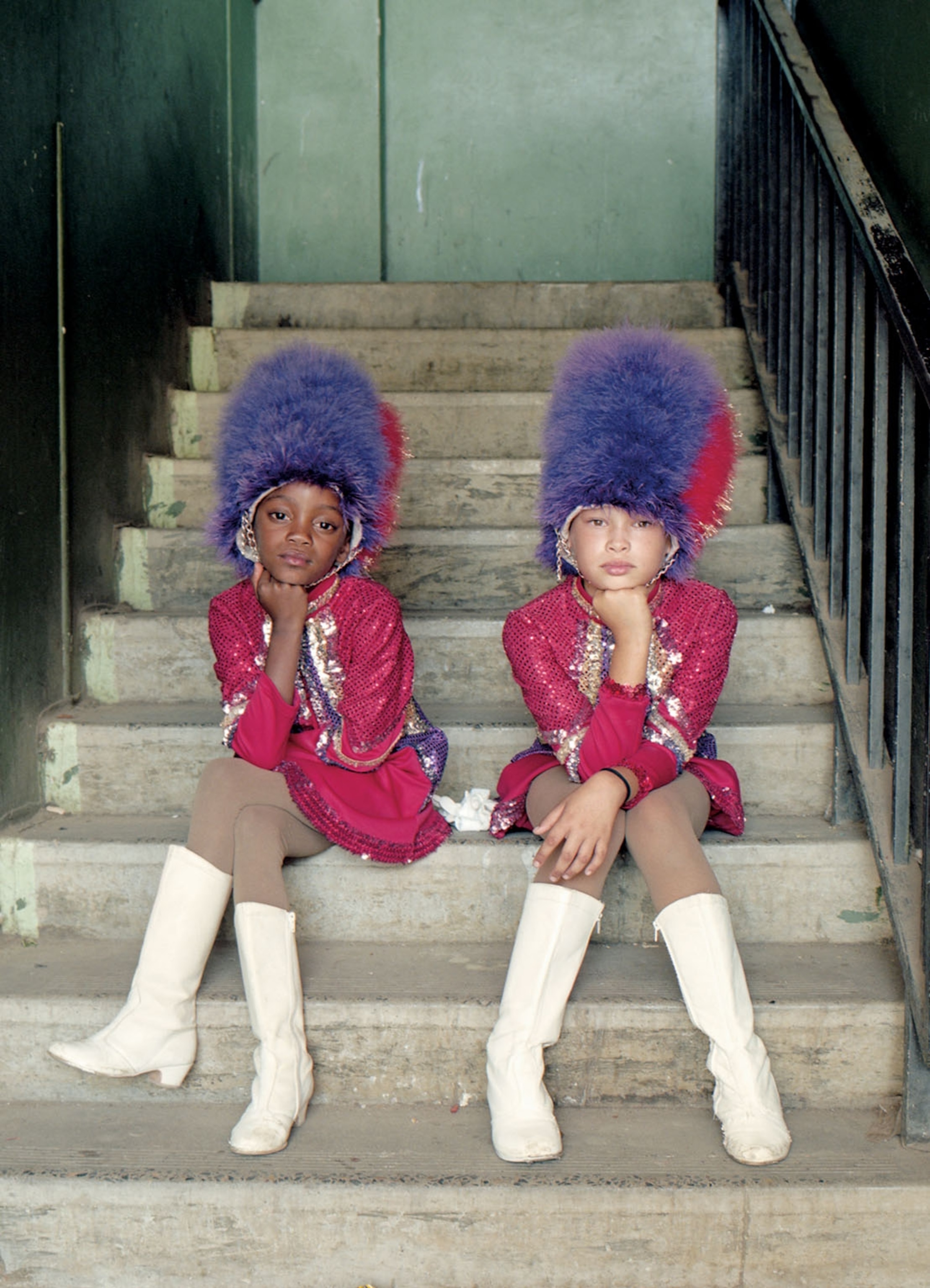 two young women in pink and purple uniforms sitting on stairs