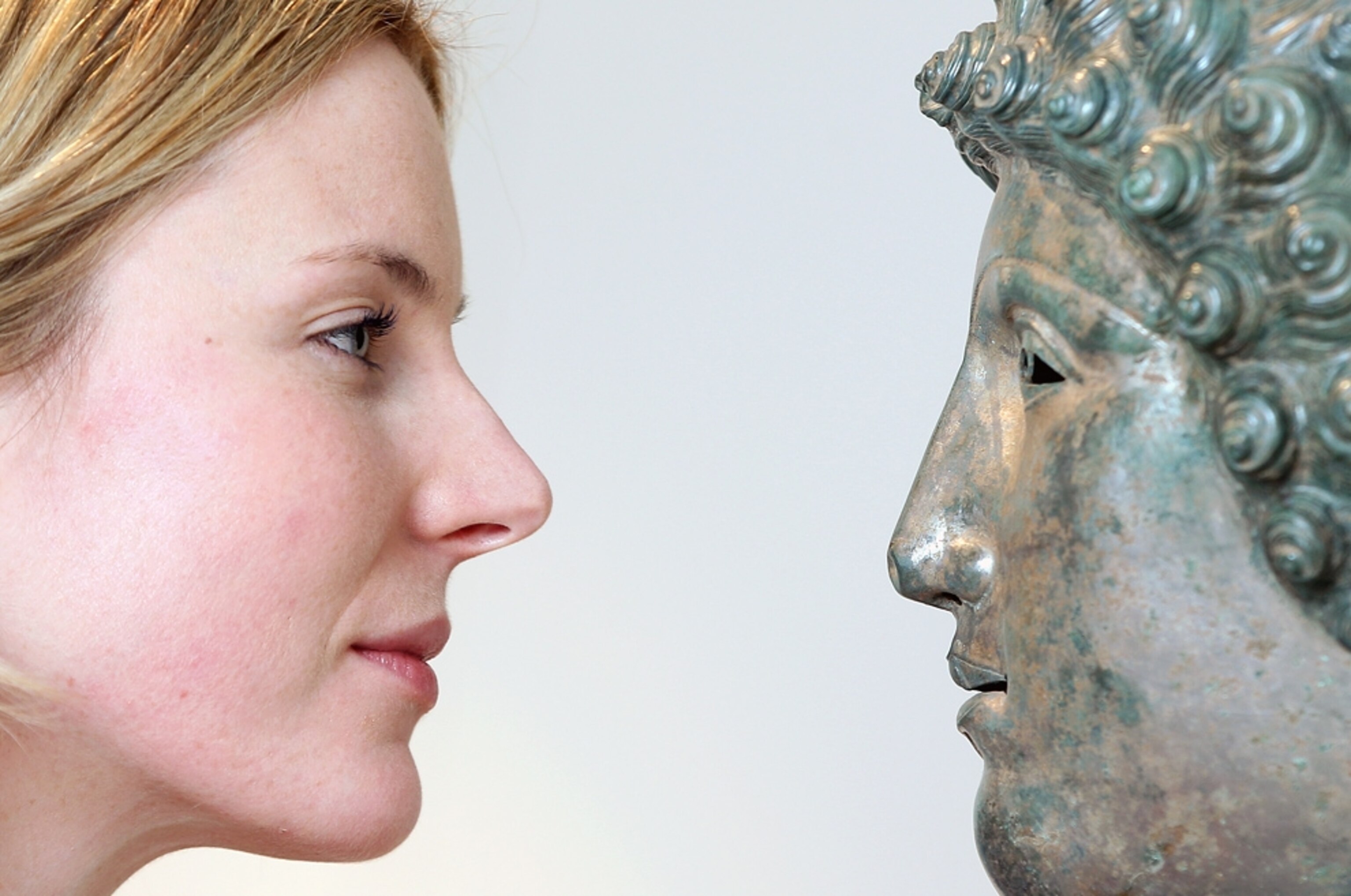 A picture of Christie's Head of Antiquities Georgiana Aitken posing with the newfound Roman helmet
