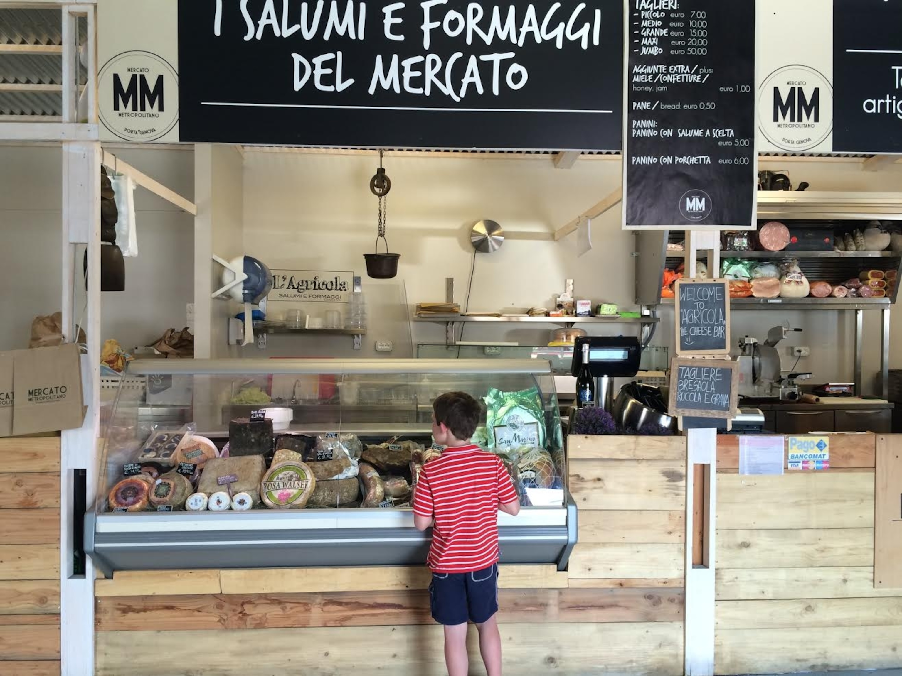 A young customer surveys his cheese options at the Mercado Metropolitano in Milan. Photograph by Mary Beth Albright