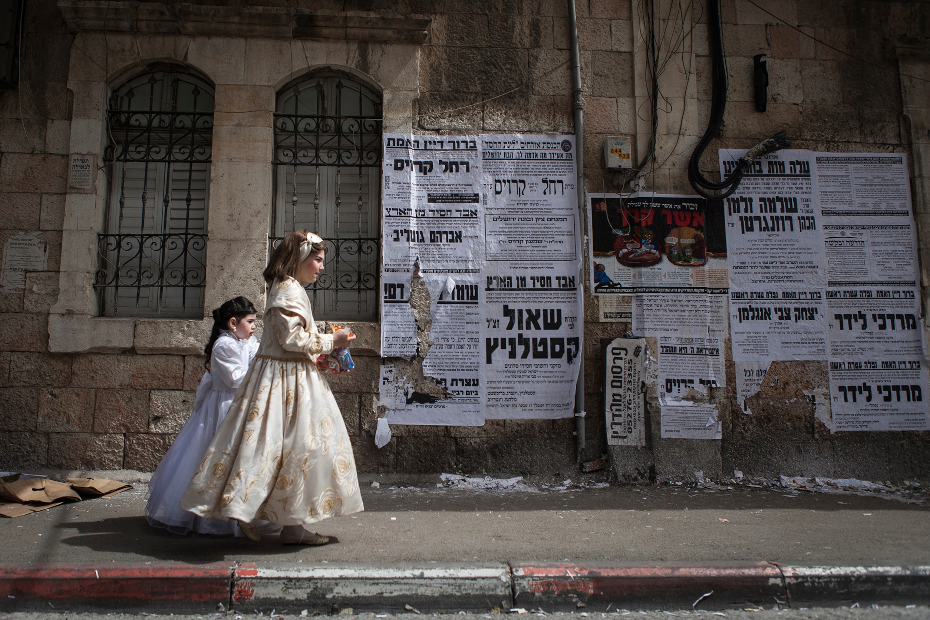 two girls dressed as princesses walking down the street